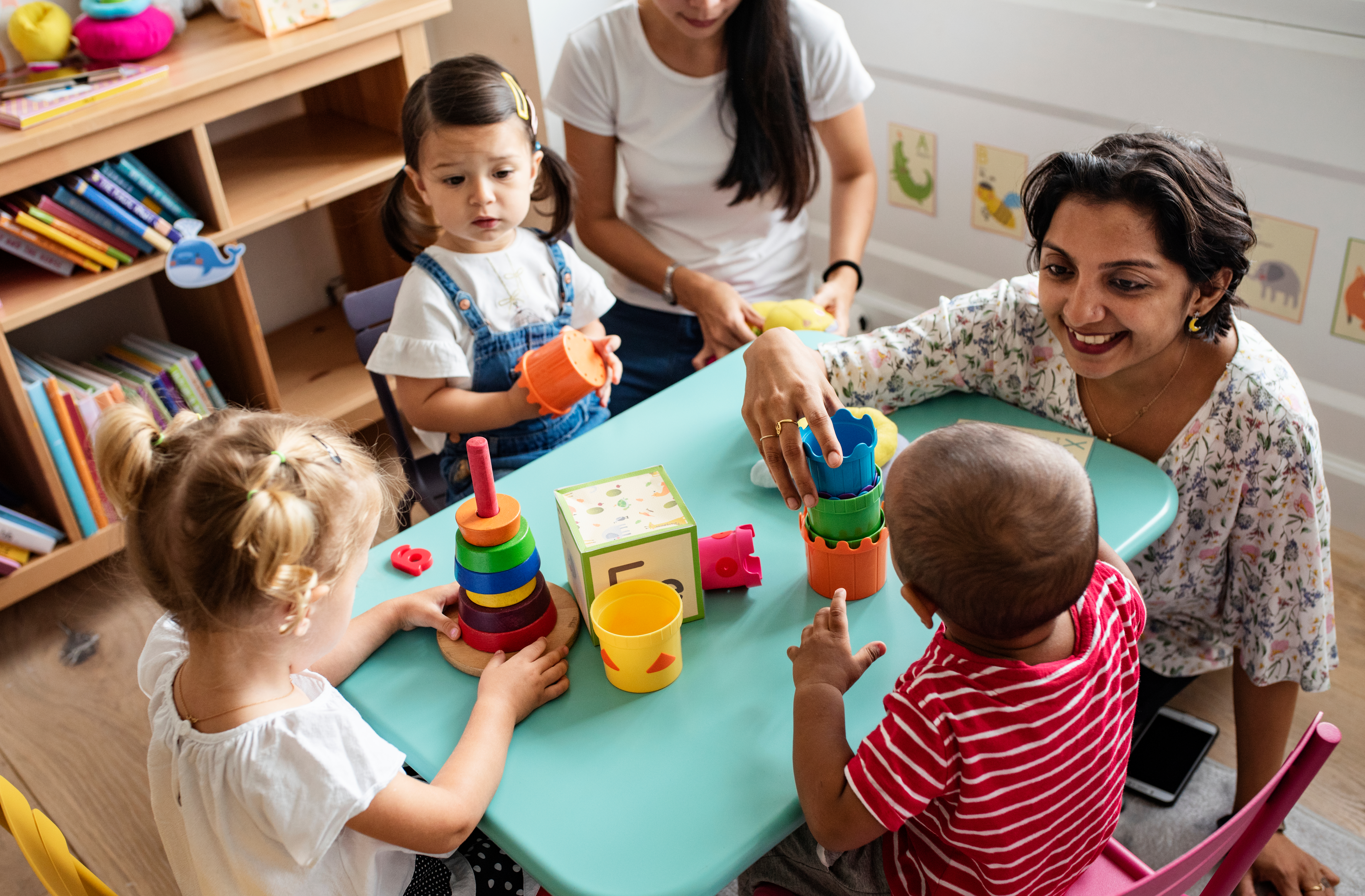 Eine Erzieherin spielt mit Kindern in einer Kindertagesstätte | Quelle: Shutterstock