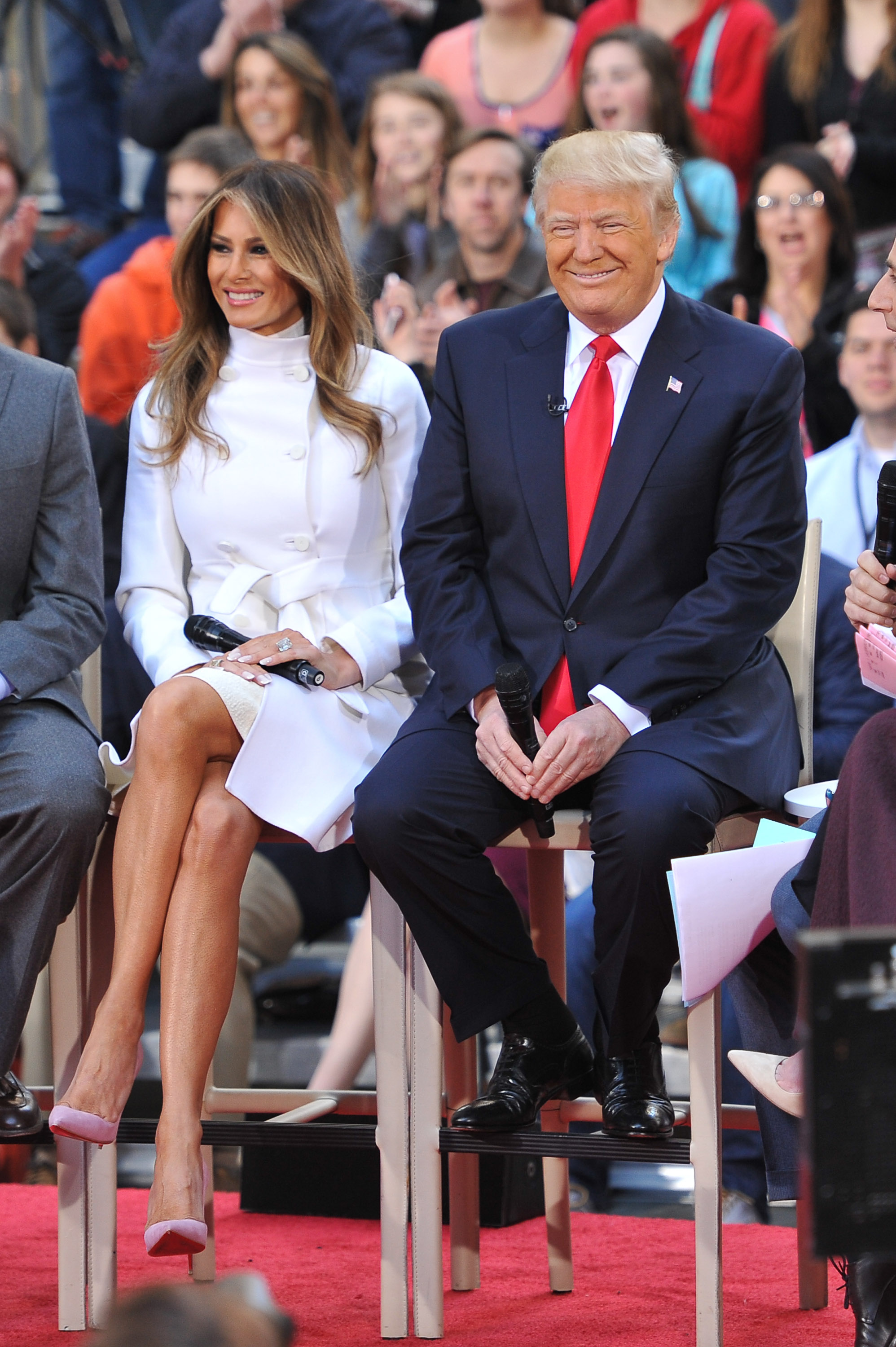 Melania Trump nimmt am 21. April 2016 an der „Today Trump Town Hall“-Veranstaltung von NBC am Rockefeller Plaza in New York City teil, Sie trug einen weißen, zweireihigen Mantel mit Gürtel über einem elfenbeinfarbenen Rollkragenpullover, ergänzt durch zartrosa Wildleder-Pumps mit spitzer Zehenpartie, die auf ihren hoch aufragenden Stiletto-Absätzen einen sanften Pastell-Akzent setzten.