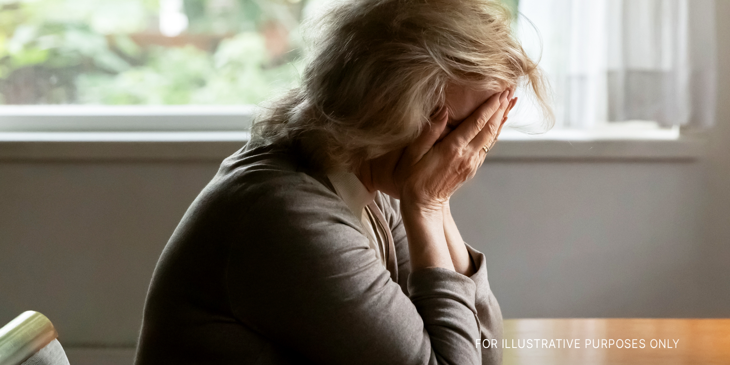 Eine ältere Frau, die ihr Gesicht mit ihren Händen bedeckt | Quelle: Shutterstock