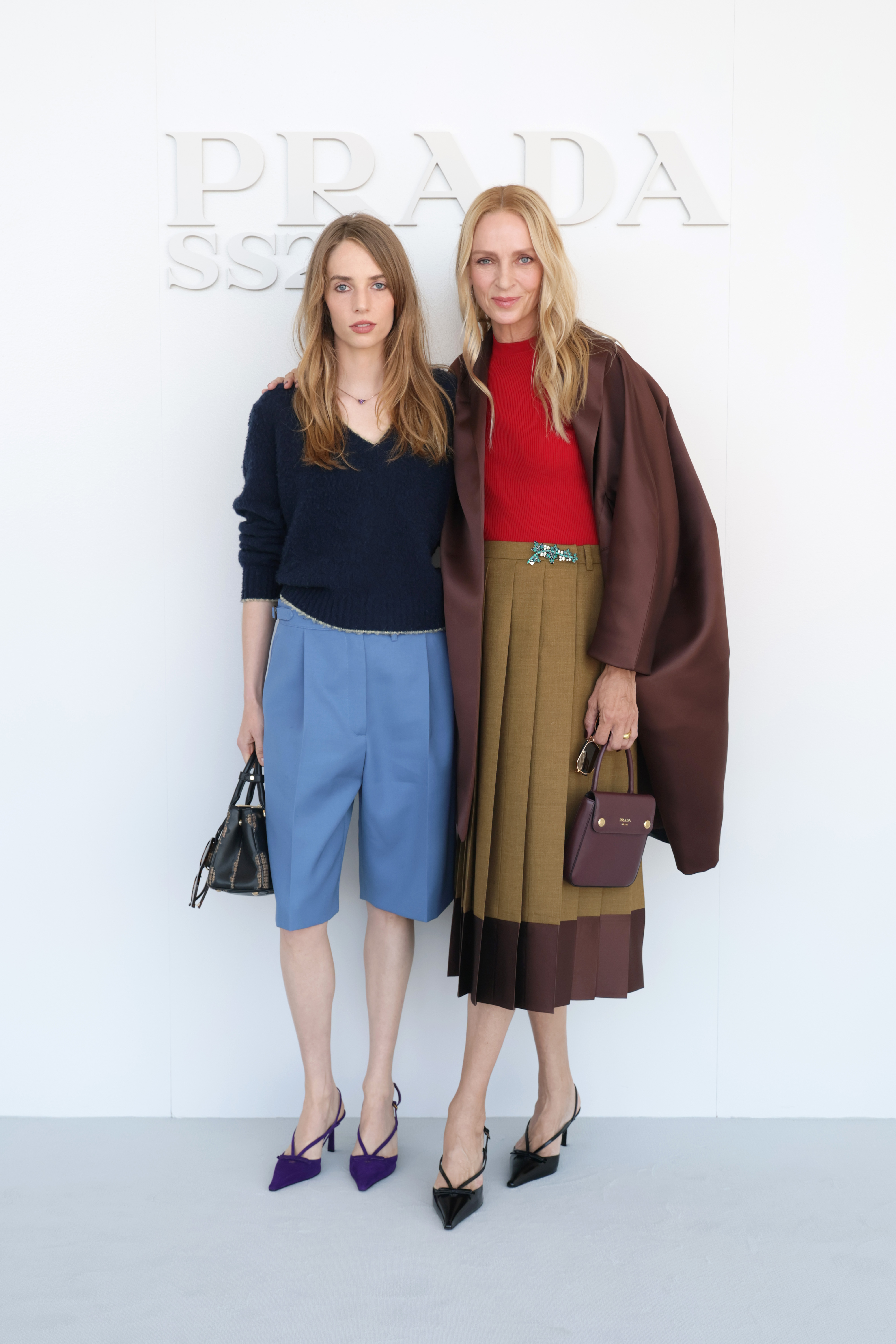Das Mutter-Tochter-Paar posiert vor der Show gemeinsam und zeigt dabei Hawkes hellblaue Shorts und lila Pumps sowie Thurmans mehrlagigen braunen Rock und Mantel. | Quelle: Getty Images