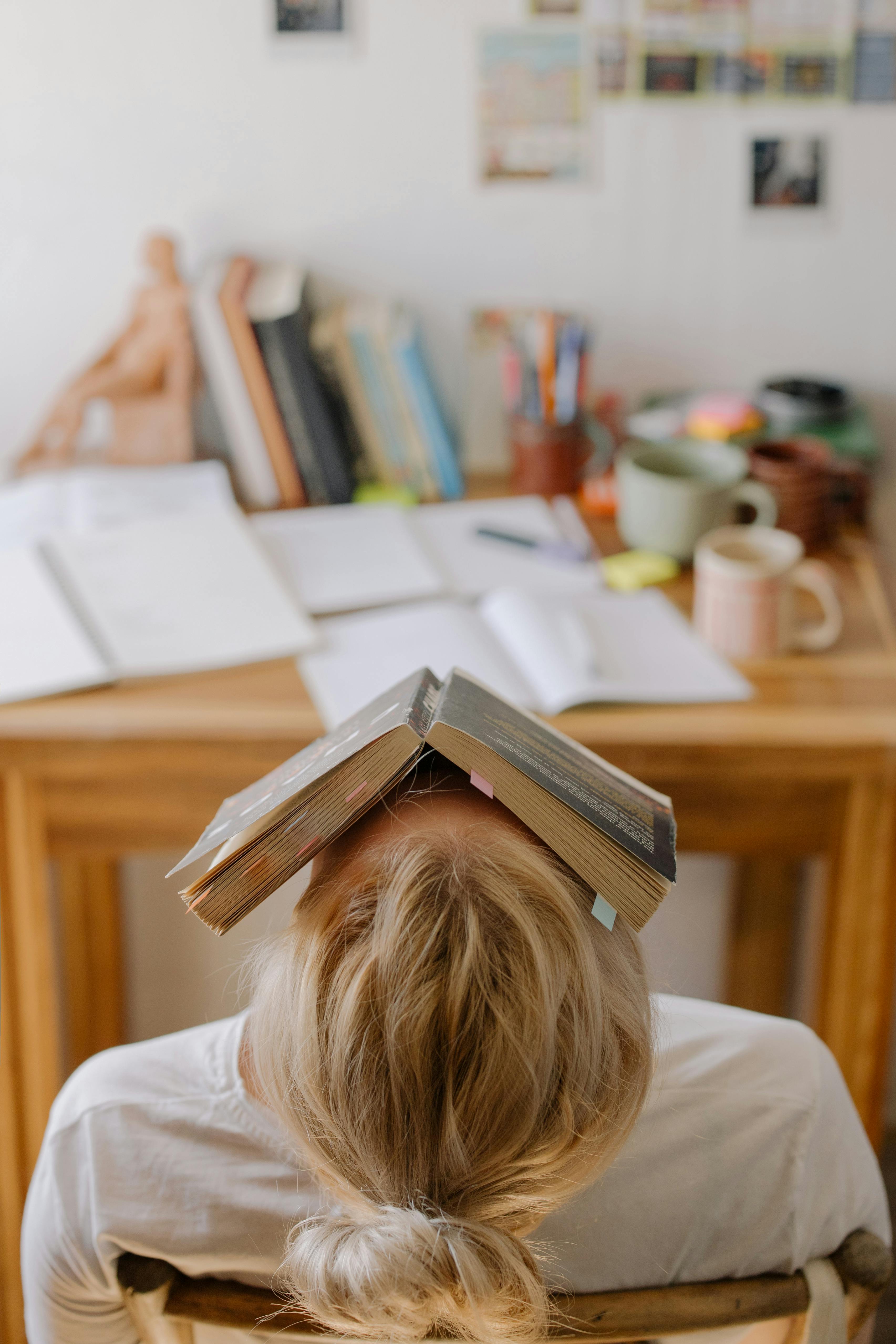 Ein müder Schüler mit einem Buch | Quelle: Pexels