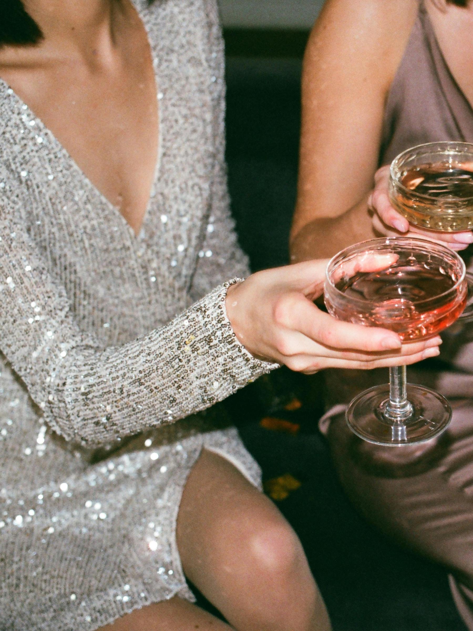 Eine Frau in einem schillernden Kleid hält ein Glas Champagner | Quelle: Pexels