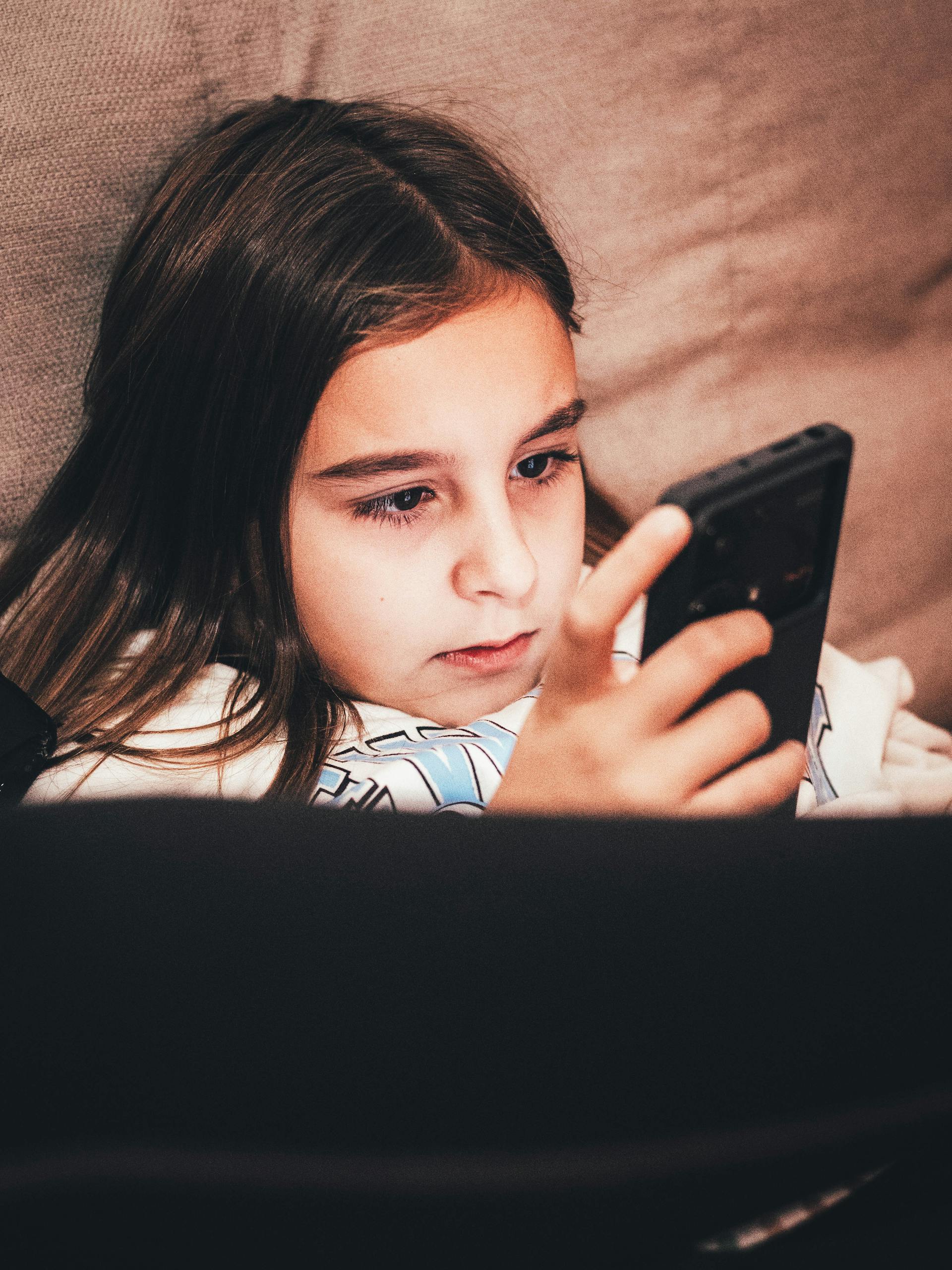 Ein junges Teenager-Mädchen starrt auf ihr Handy | Quelle: Pexels