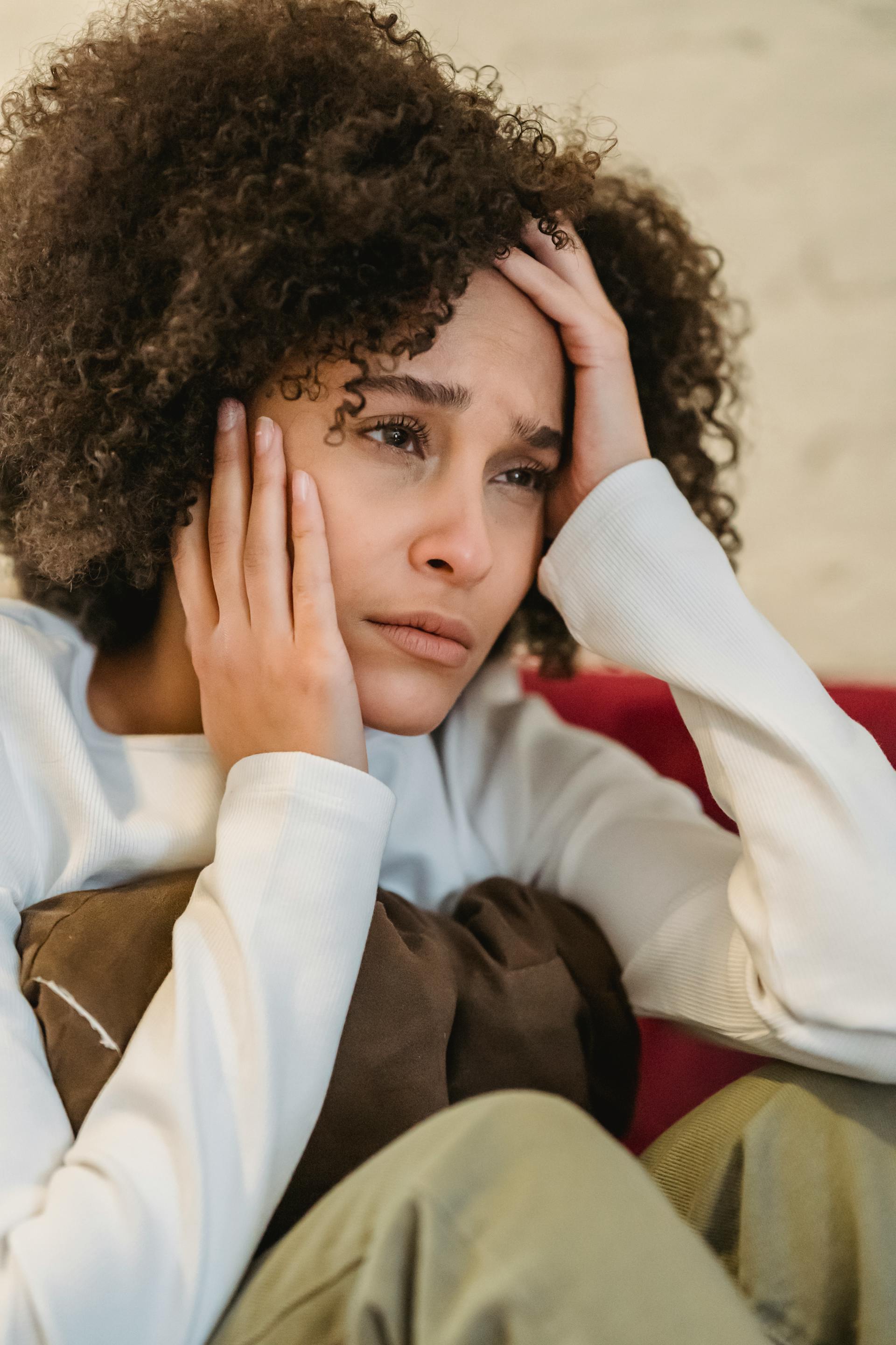 Eine angespannte Frau mit dem Kopf in ihren Händen | Quelle: Pexels