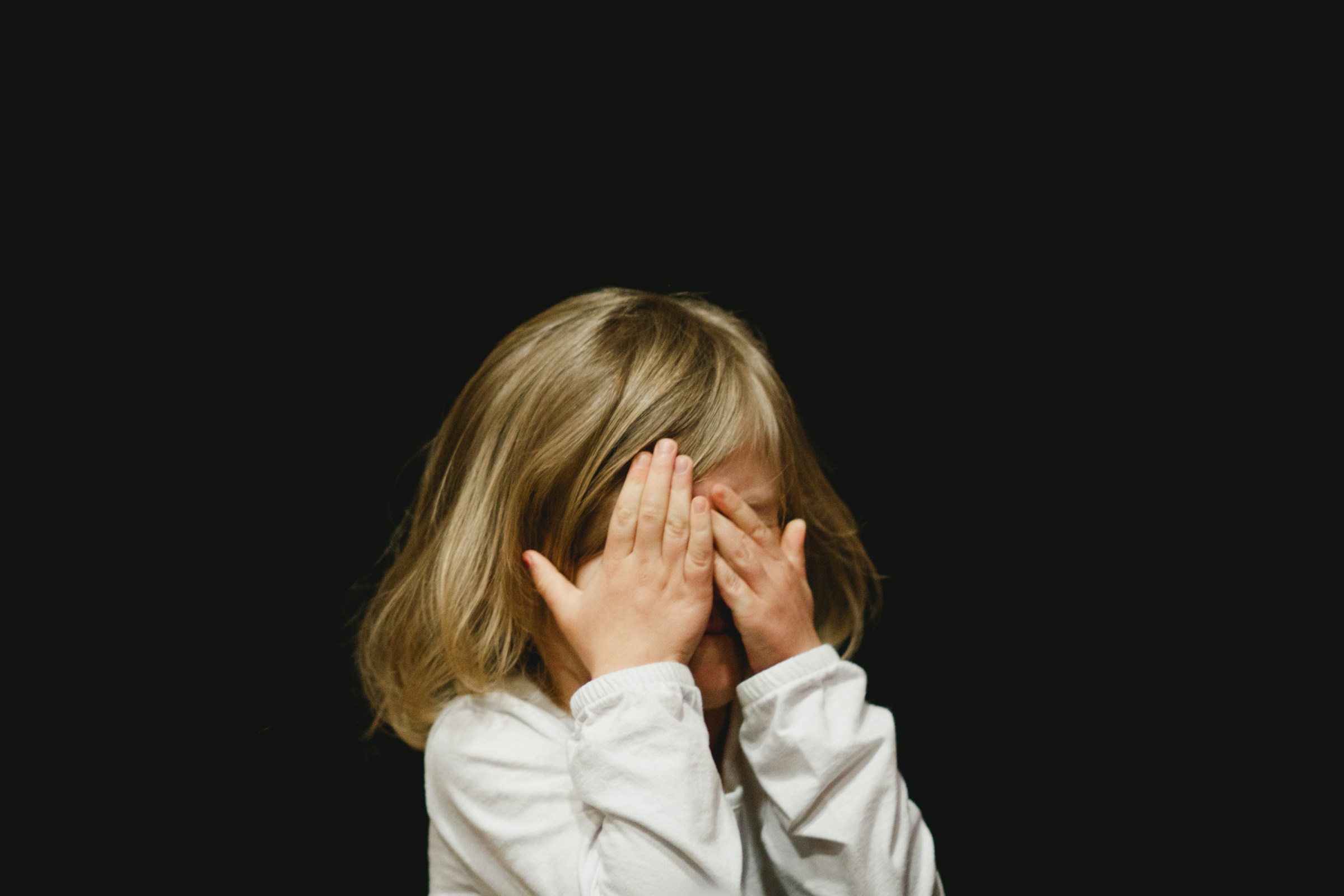 Ein kleines Mädchen, das sein Gesicht bedeckt | Quelle: Unsplash