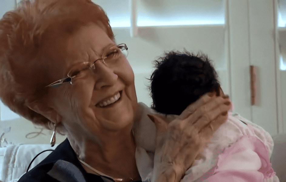 Joy Ringhofer hält lachend das Neugeborene. | Quelle: Youtube.com/Inside Edition