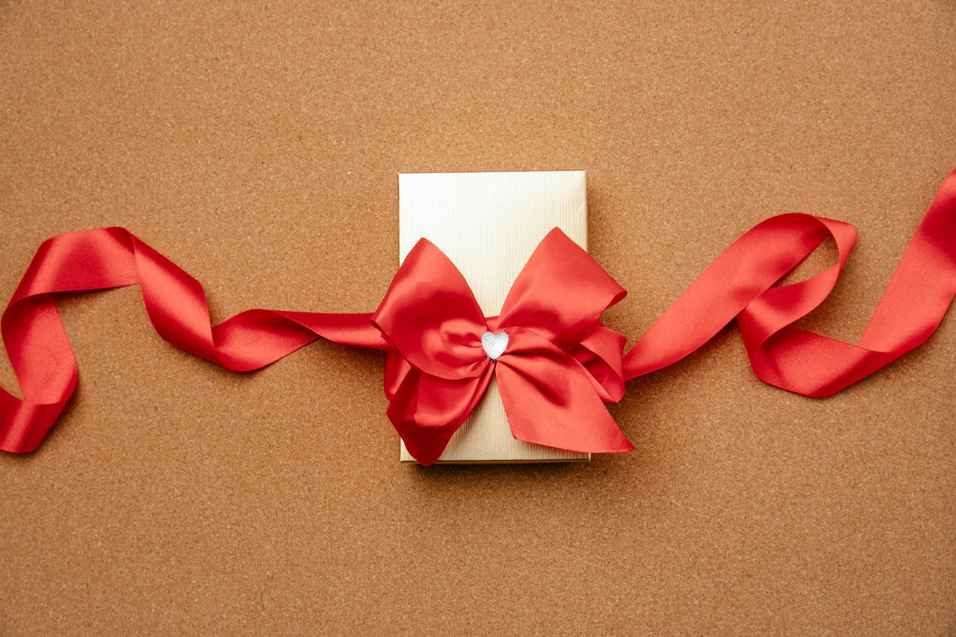 Eine kleine Geschenkschachtel, verziert mit einer roten Schleife | Quelle: Pexels