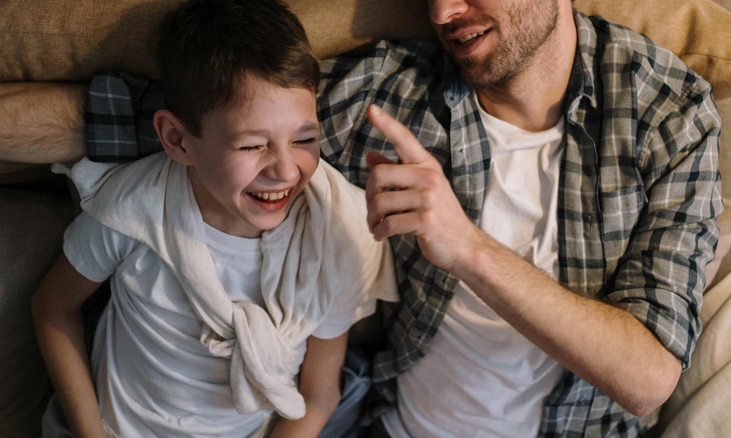 Ein Mann und ein Junge lachen zusammen | Quelle: Pexels