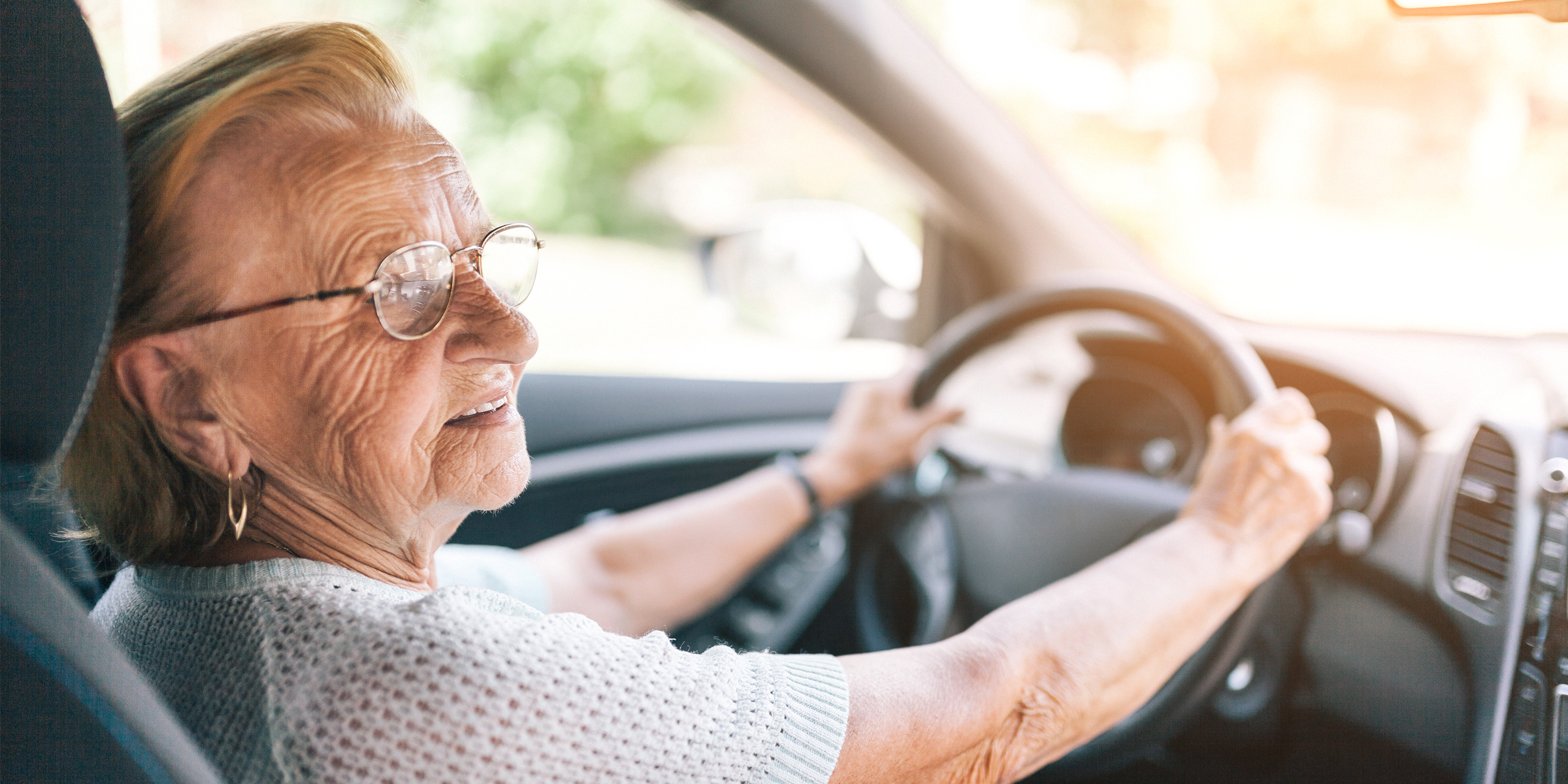 Eine alte Frau, die ein Lenkrad hält | Quelle: Shutterstock