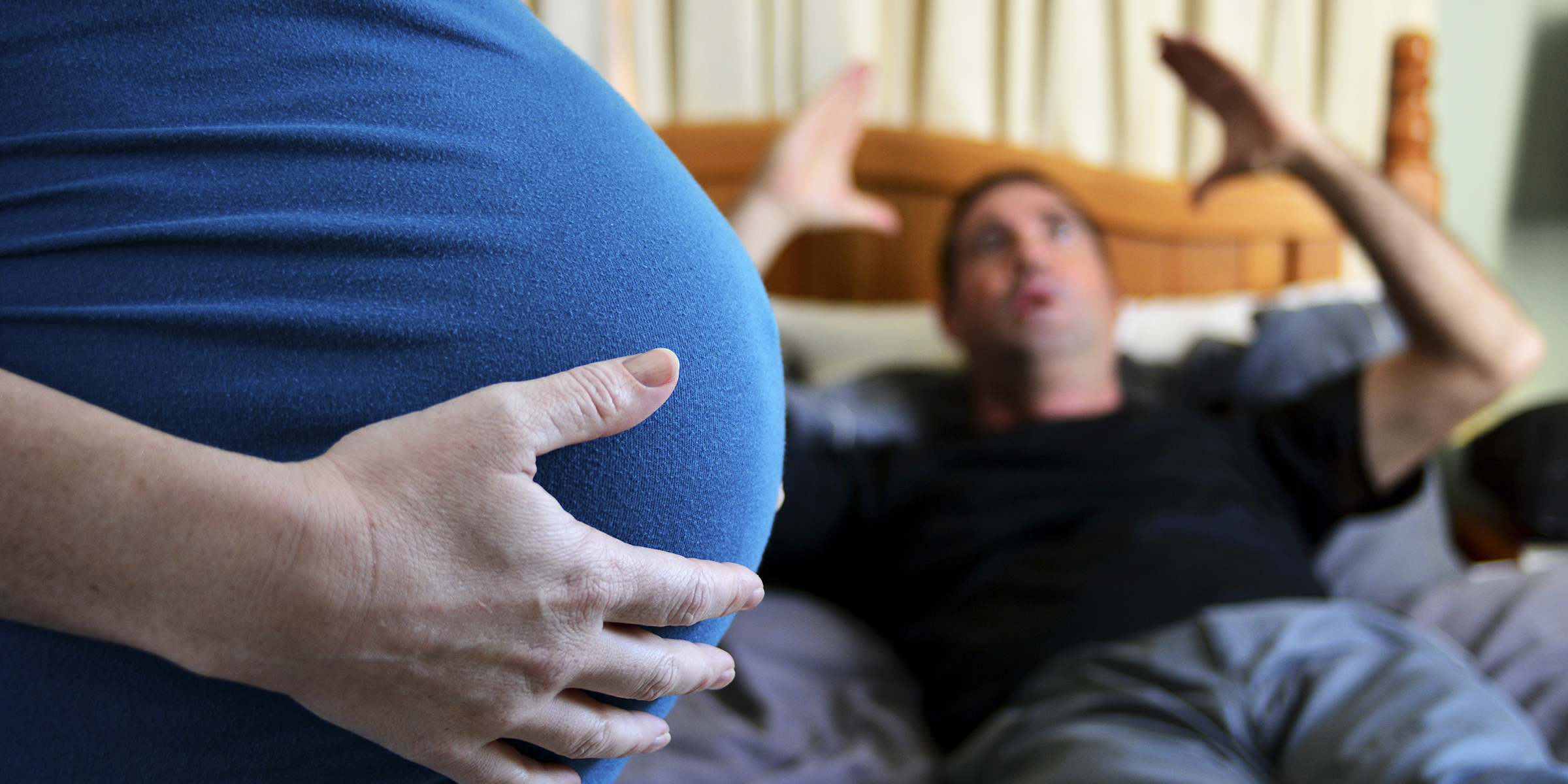 Eine schwangere Frau mit einem wütenden Mann im Hintergrund | Quelle: Shutterstock