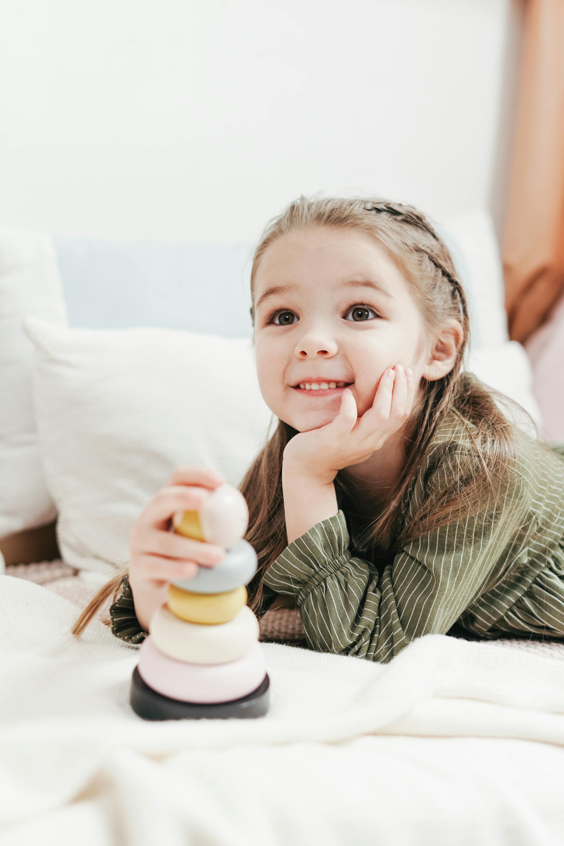 Ein lächelndes kleines Mädchen mit einem Spielzeug | Quelle: Pexels