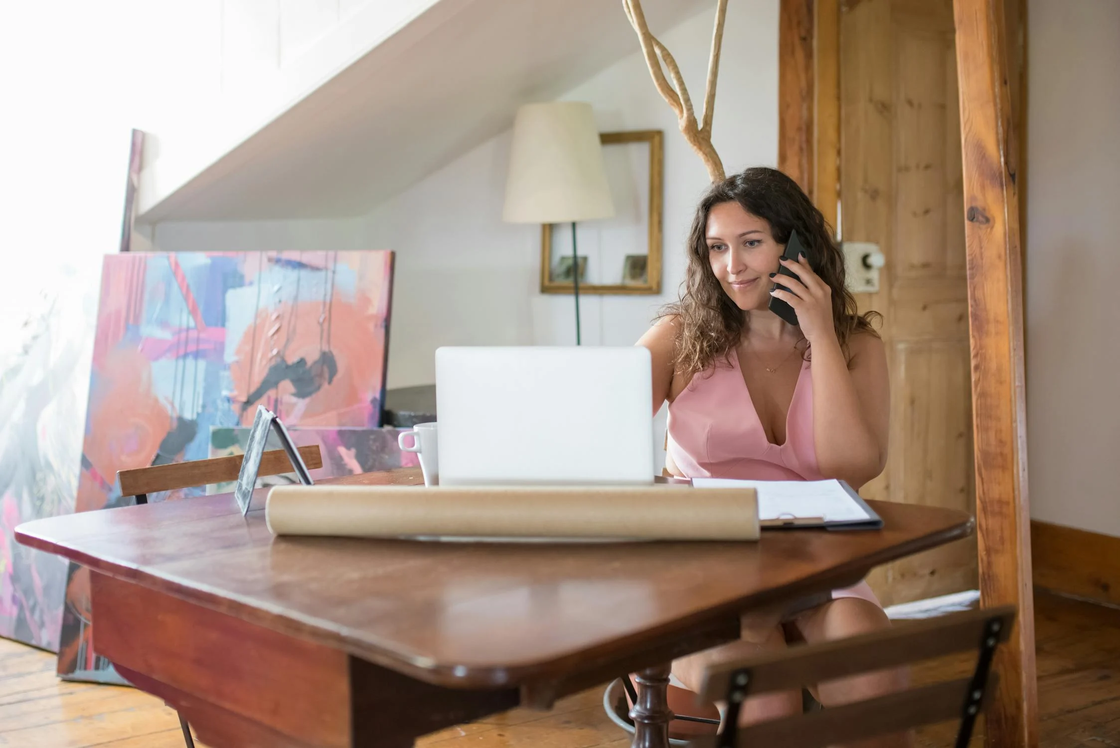 Eine Frau, die telefoniert und auf ihren Laptop schaut | Quelle: Pexels