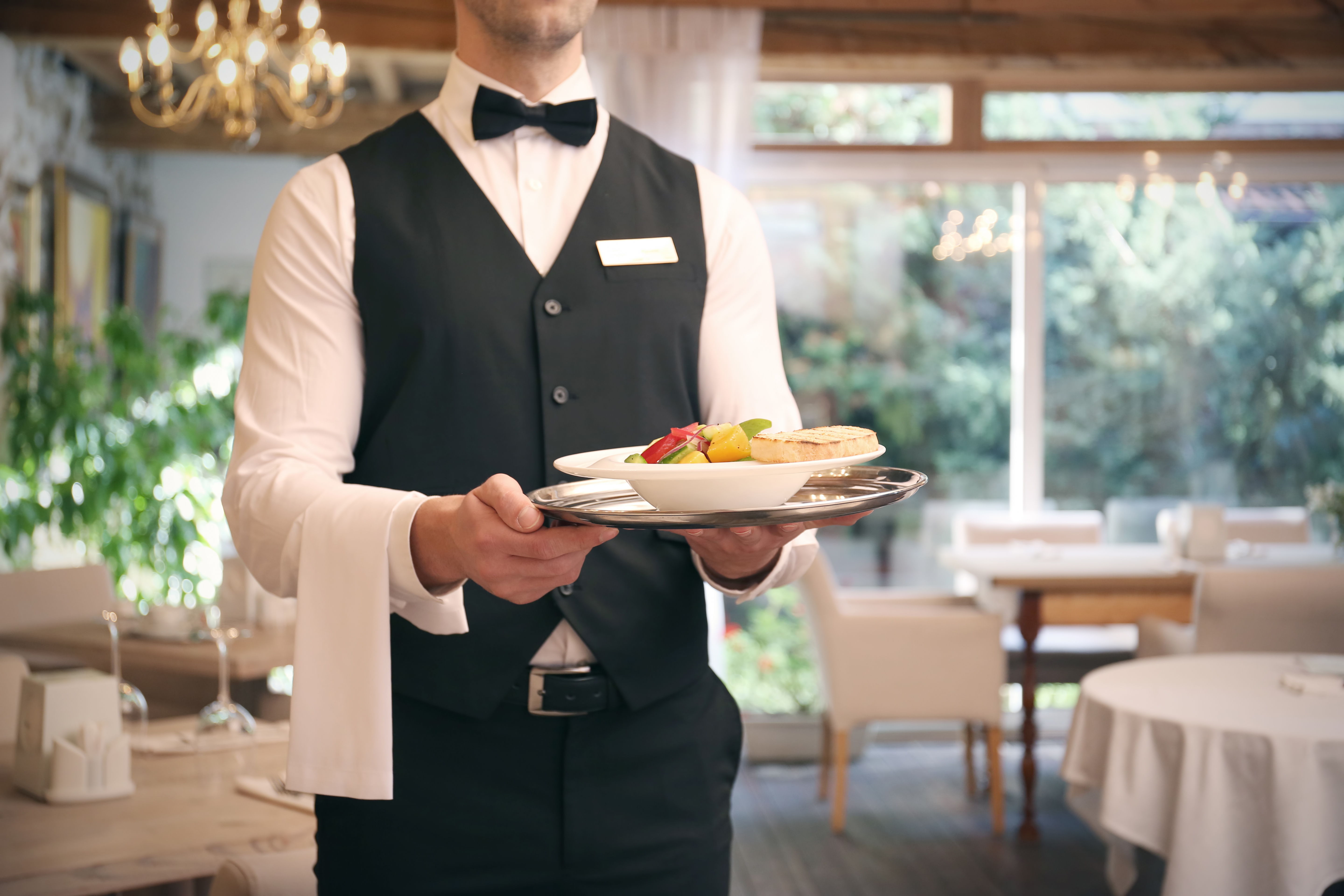Ein Kellner serviert das Essen im Restaurant | Quelle: Shutterstock