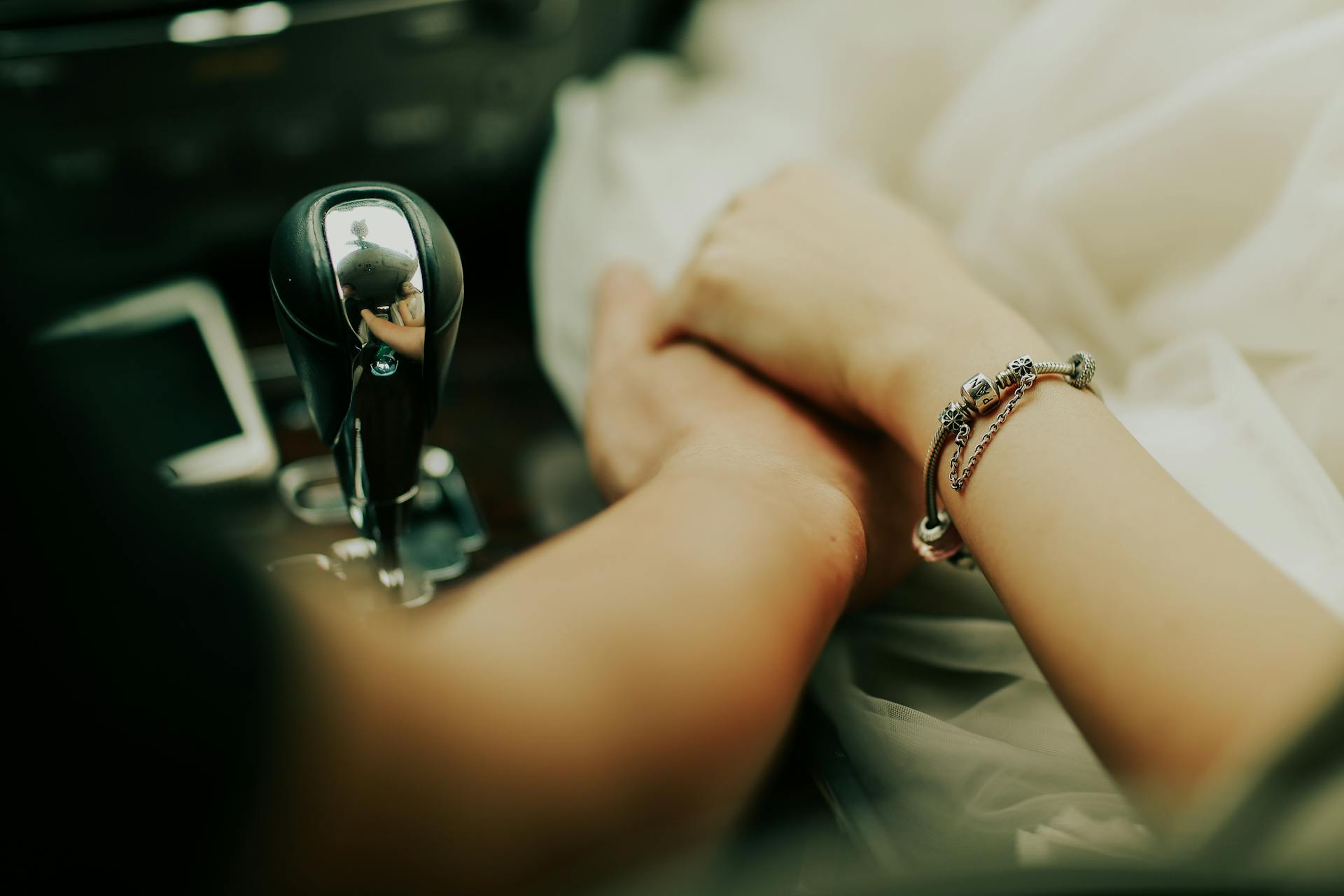 Ein Paar sitzt im Auto und hält sich an den Händen | Quelle: Pexels