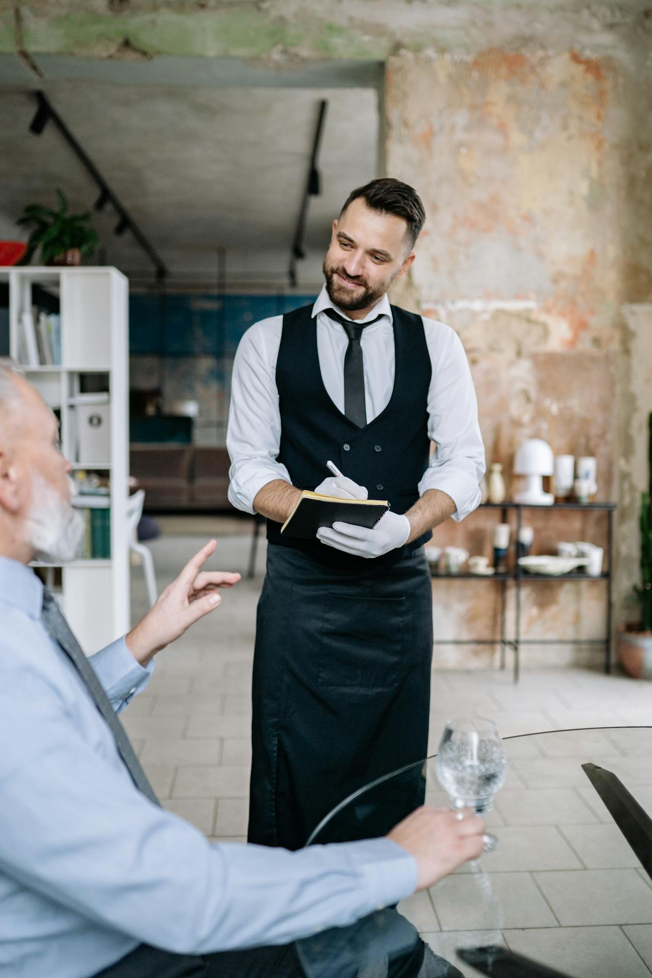 Ein Kellner nimmt die Bestellung eines Kunden in einem Restaurant auf | Quelle: Pexels