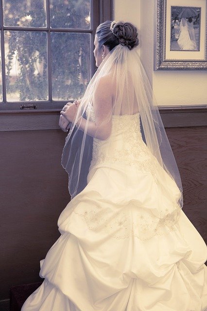  Eine Braut steht vor einem Fenster und schaut nach draußen | Quelle: Pixabay