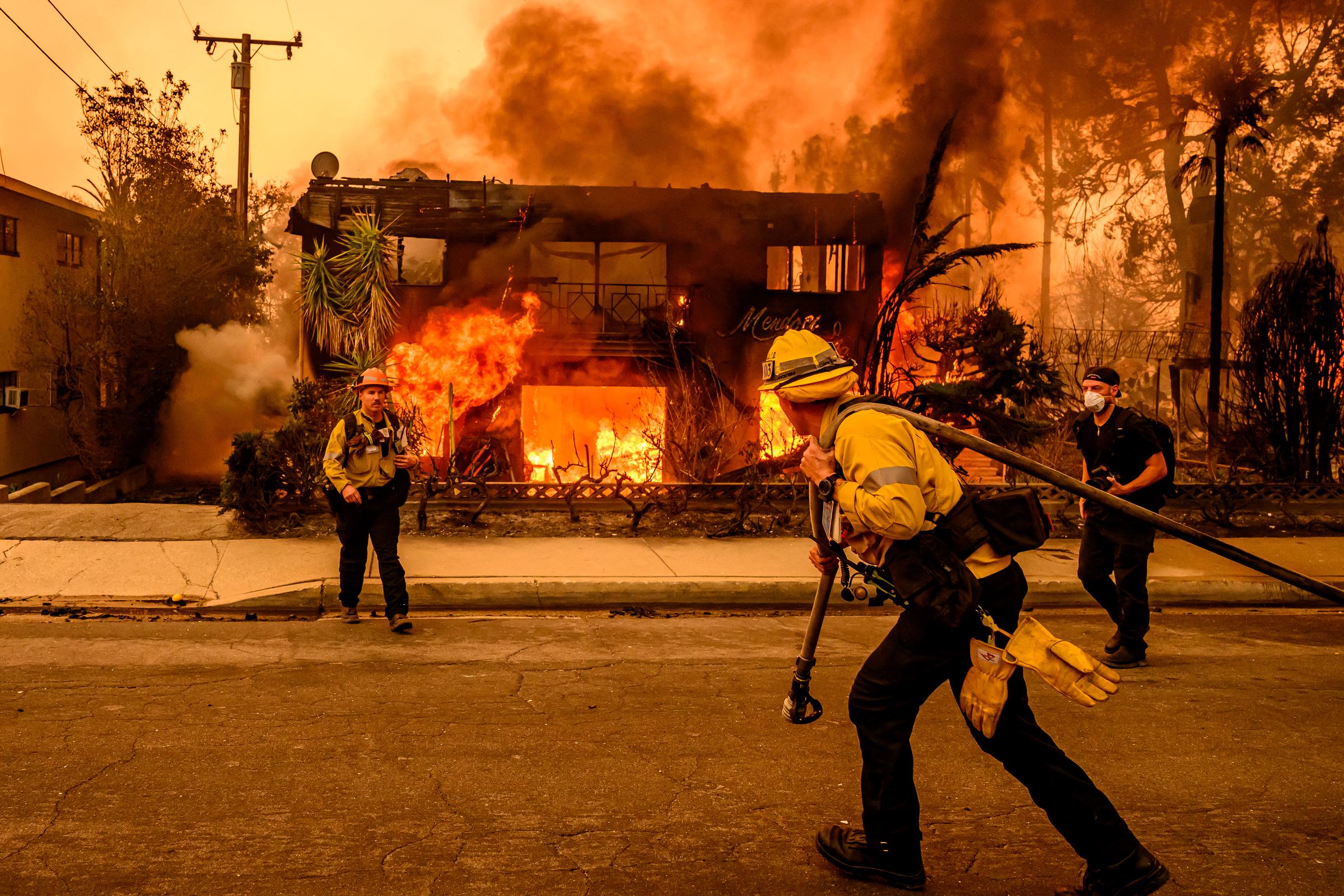 Feuerwehrleute arbeiten an einem brennenden Wohnhaus während des Eaton-Brandes in Altadena im Bezirk Los Angeles, Kalifornien, am 8. Januar 2025 | Quelle: Getty Images