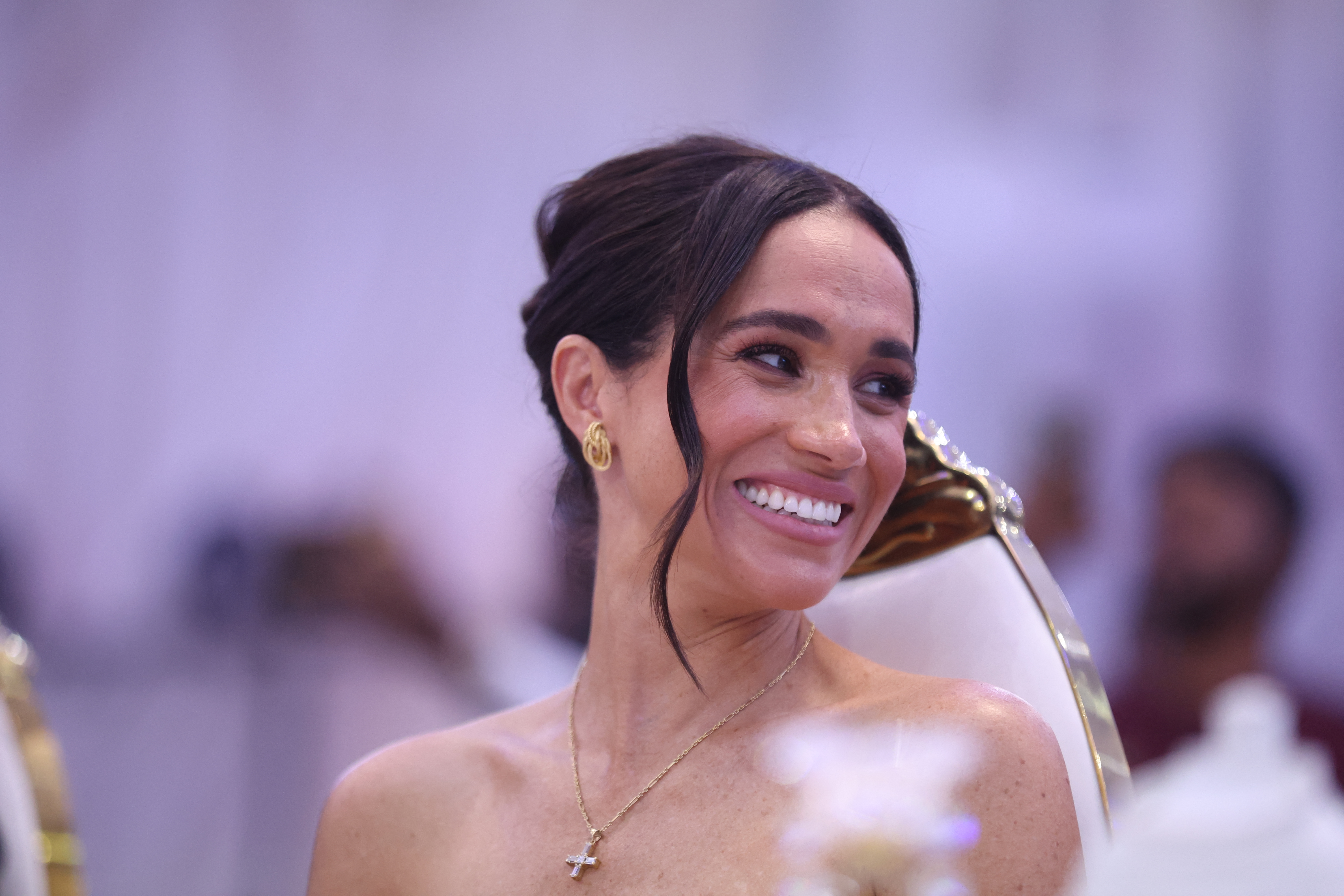 Meghan Markle lächelt, als sie am 11. Mai 2024 im nigerianischen Verteidigungshauptquartier in Abuja an einem Sit Out mit Prinz Harry teilnimmt. | Quelle: Getty Images