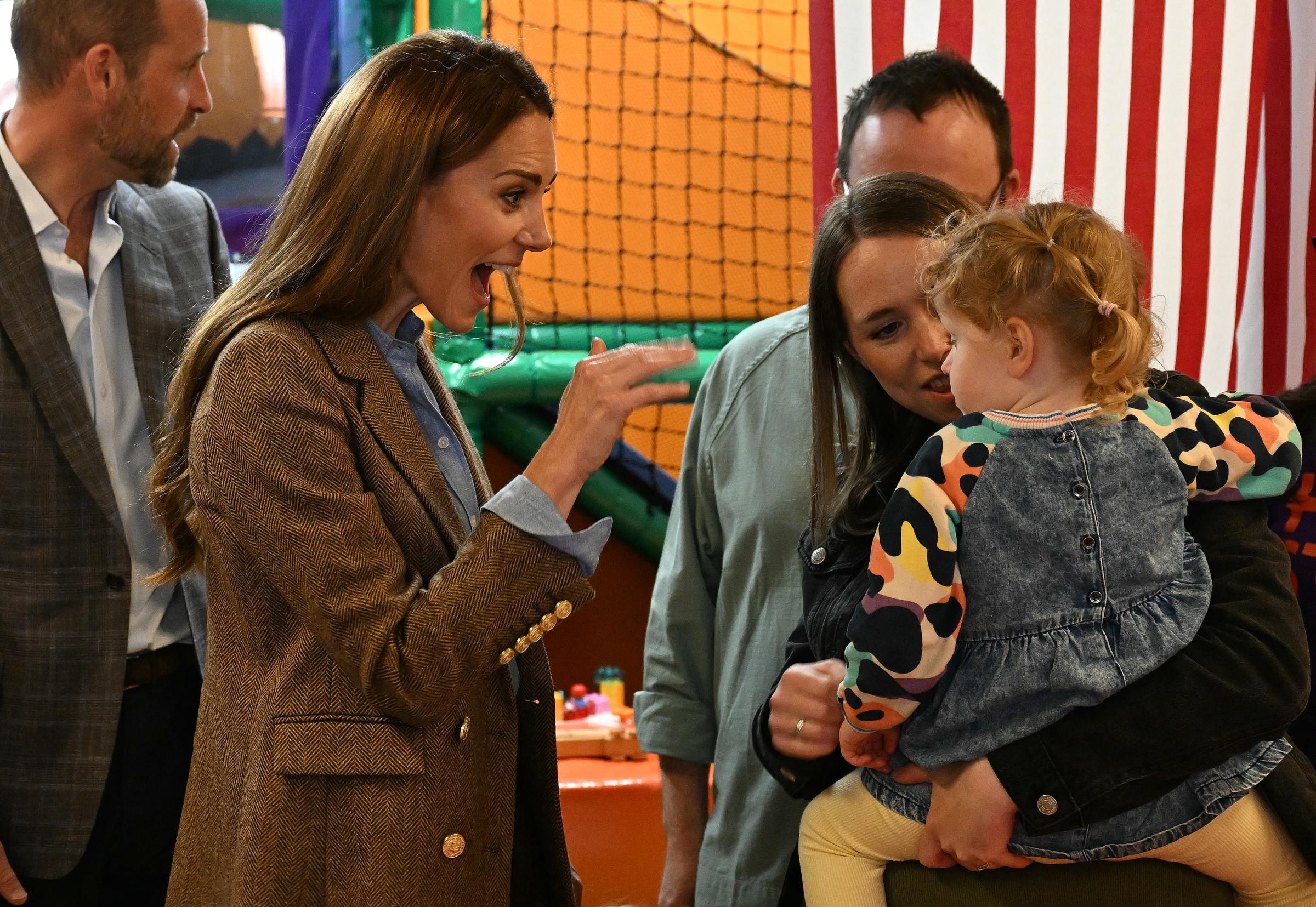 Catherine reagiert spielerisch auf ein kleines Kind, als sie den Softplay-Bereich in der Aros Hall in Tobermory besucht. Ihr lebhafter Gesichtsausdruck verlieh der Begegnung des Paares mit Familien auf der Isle of Mull eine warme, persönliche Note.