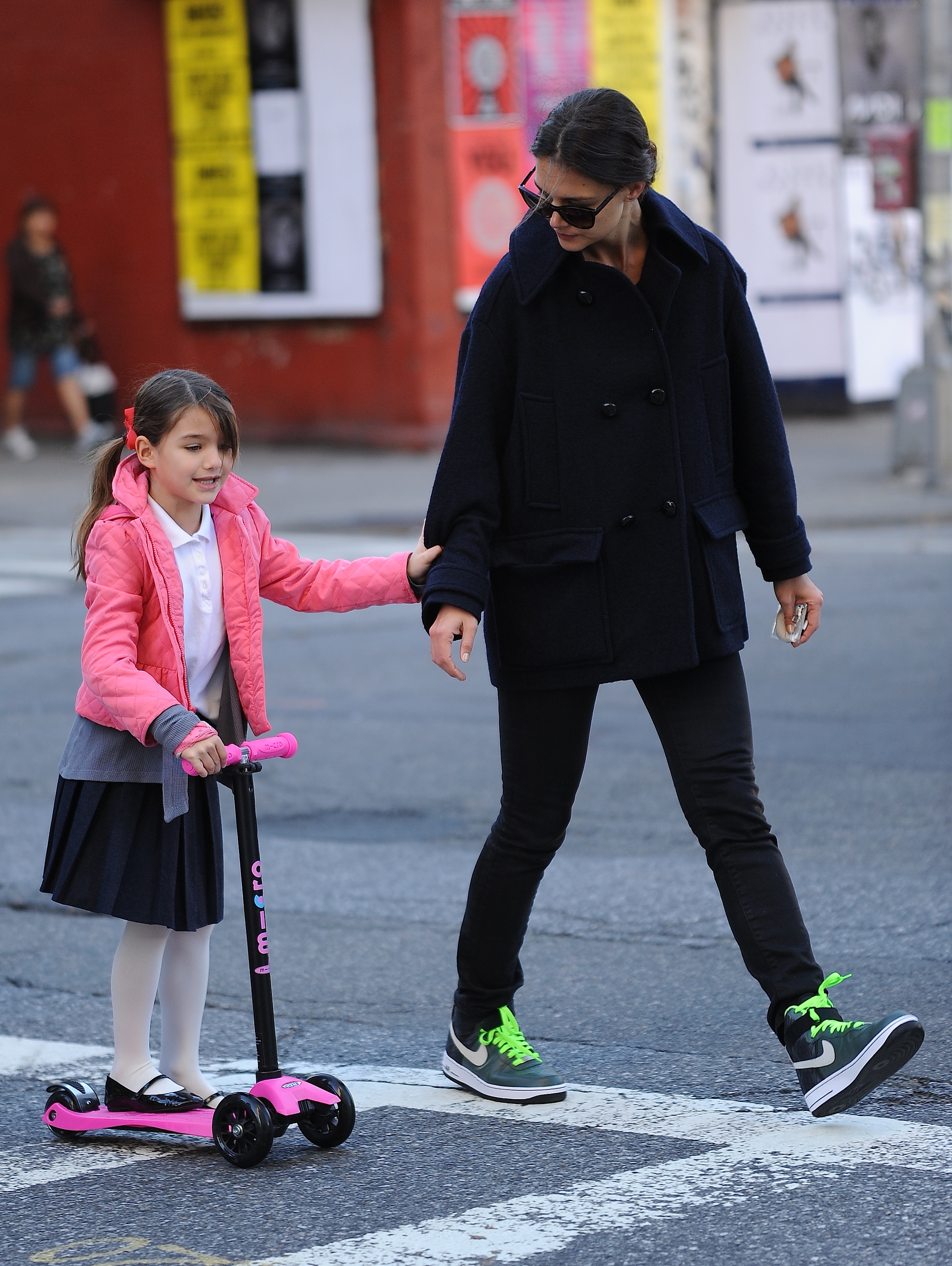 Katie Holmes hilft Suri Cruise am 8. Oktober 2013 in New York City beim Rollerfahren. | Quelle: Getty Images