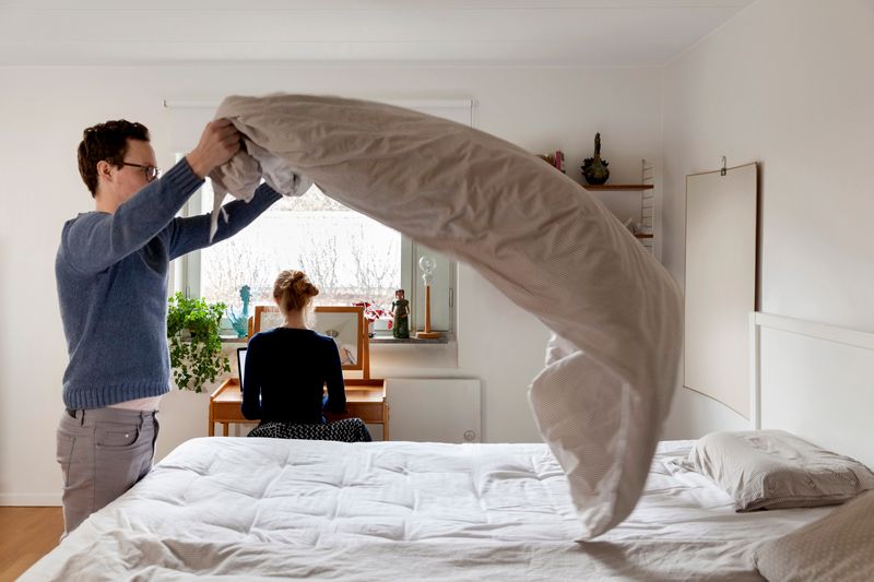 Ein Mann macht sein Bett. | Quelle: Getty Images