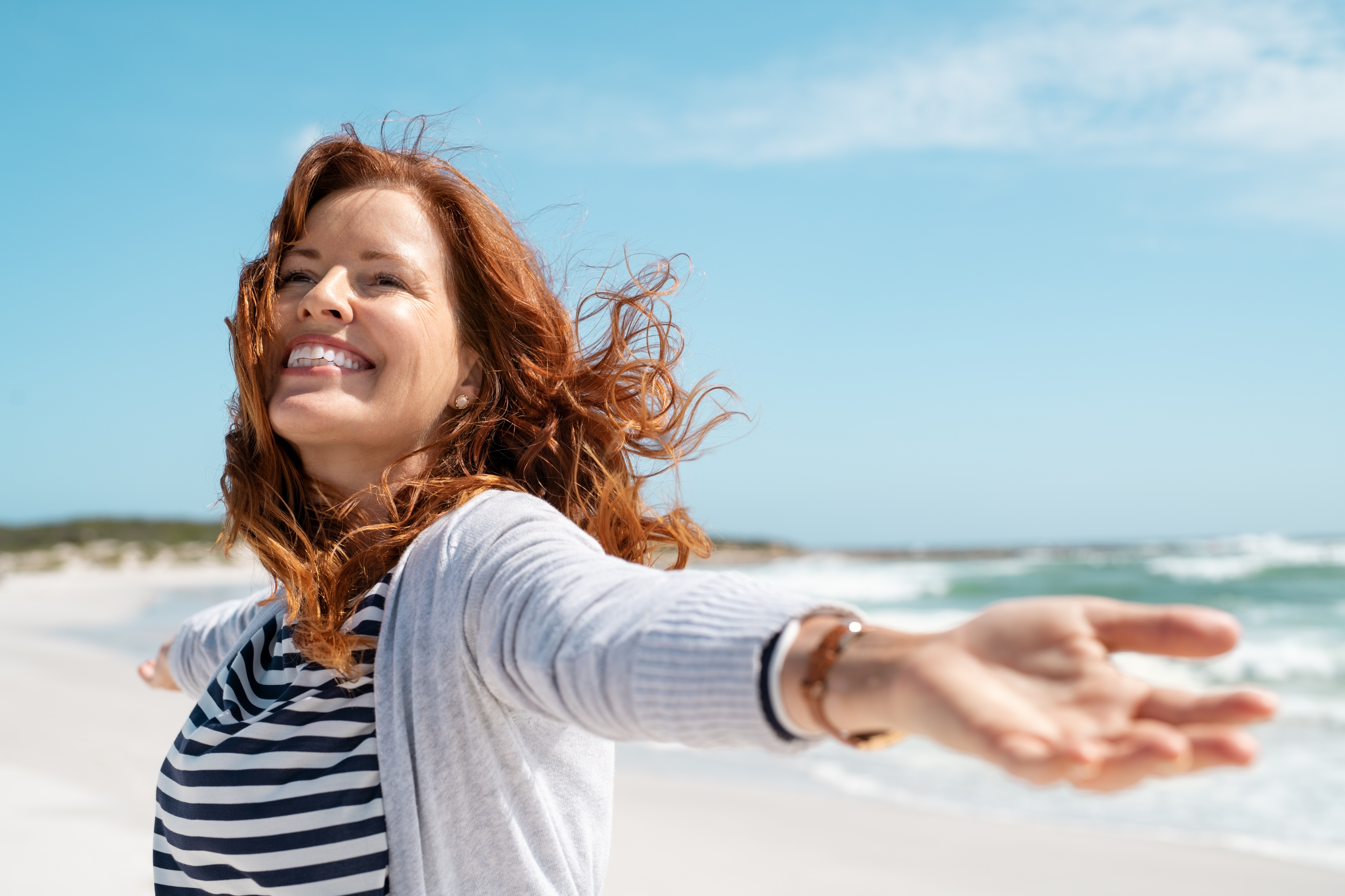 Eine glückliche Frau am Meer | Quelle: Shutterstock