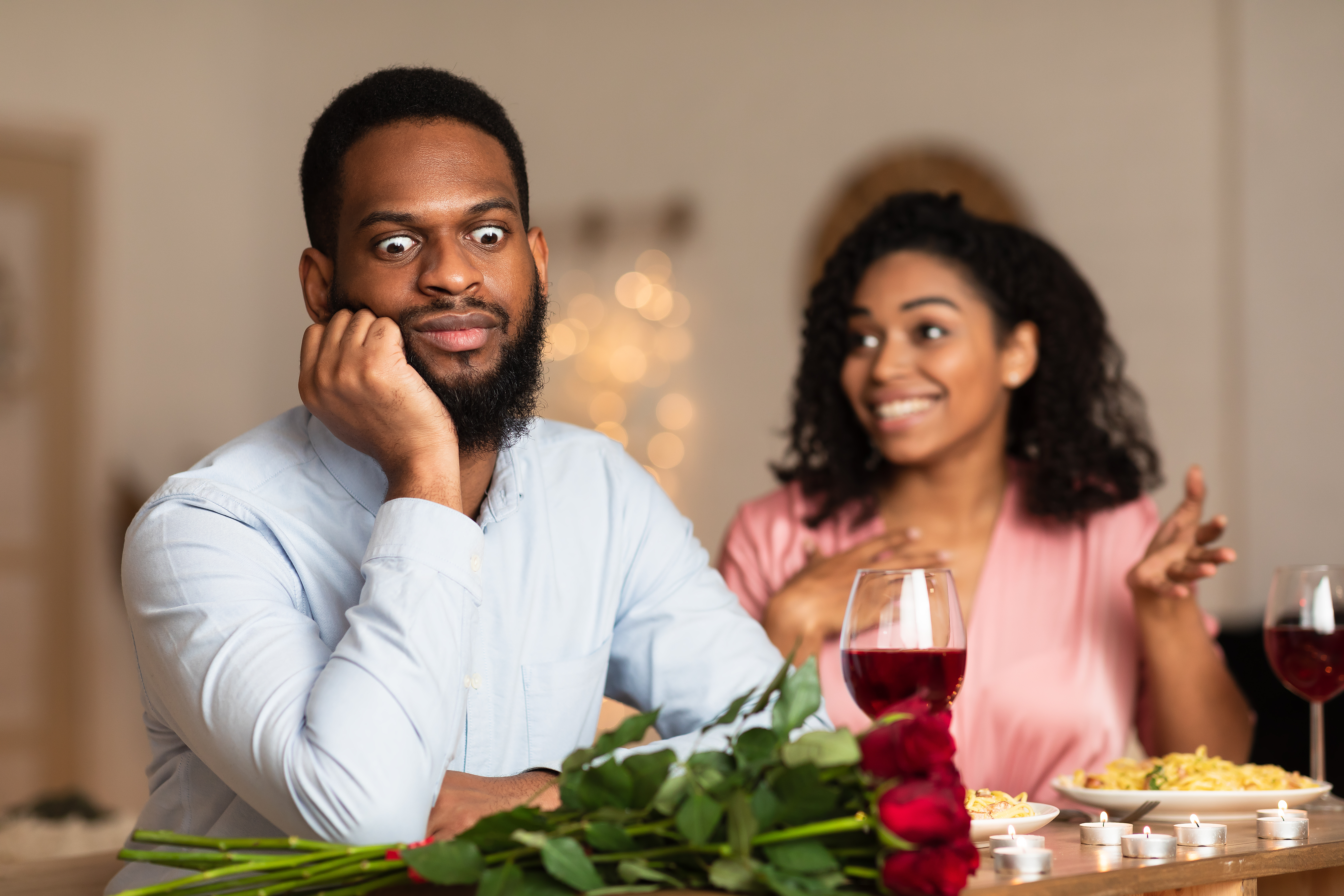 Unzufriedener, schockierter schwarzer Mann hört einer aufgeregten und emotionalen Frau zu | Quelle: Shutterstock