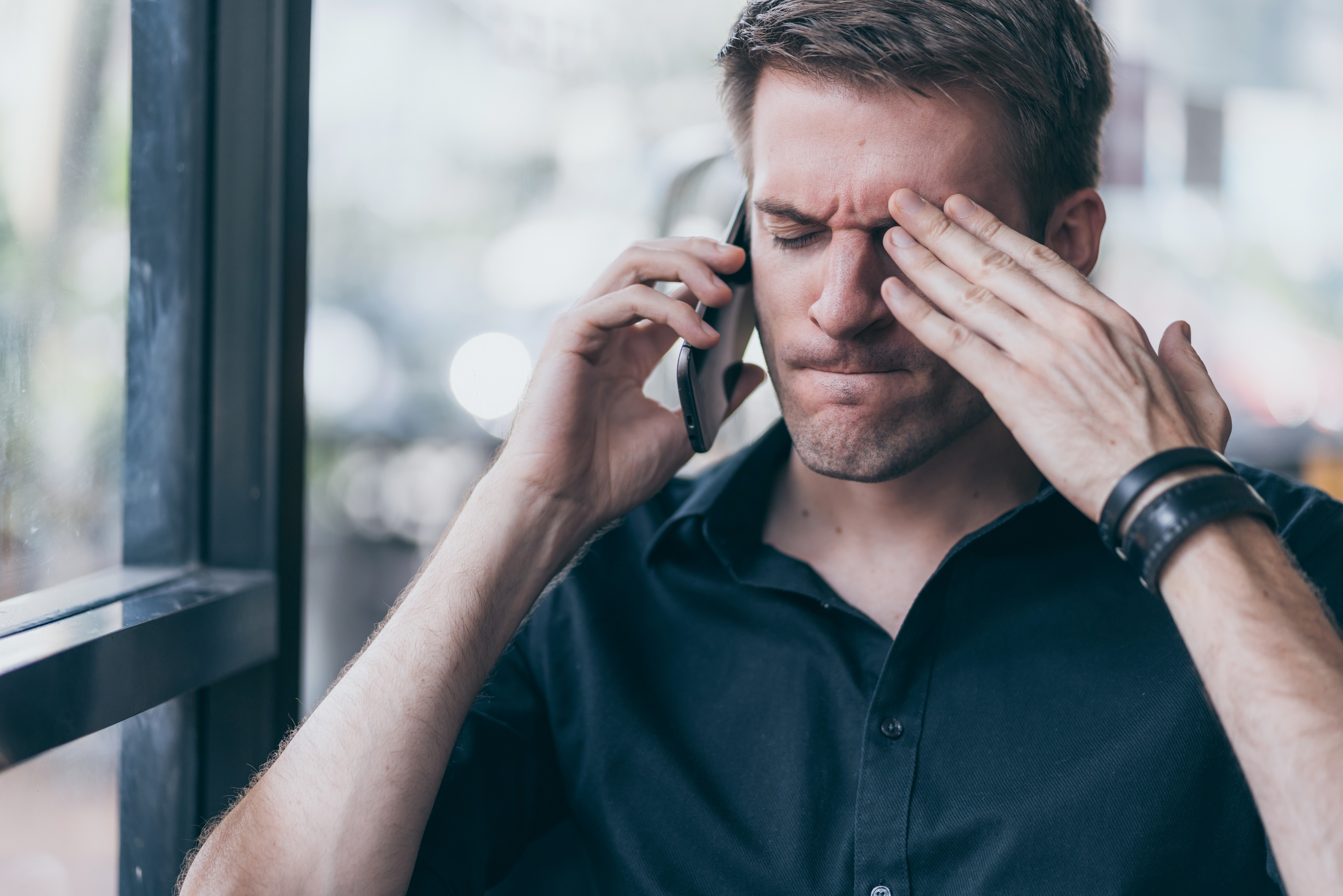 Ein gestresster Mann beim Telefonieren | Quelle: Shutterstock