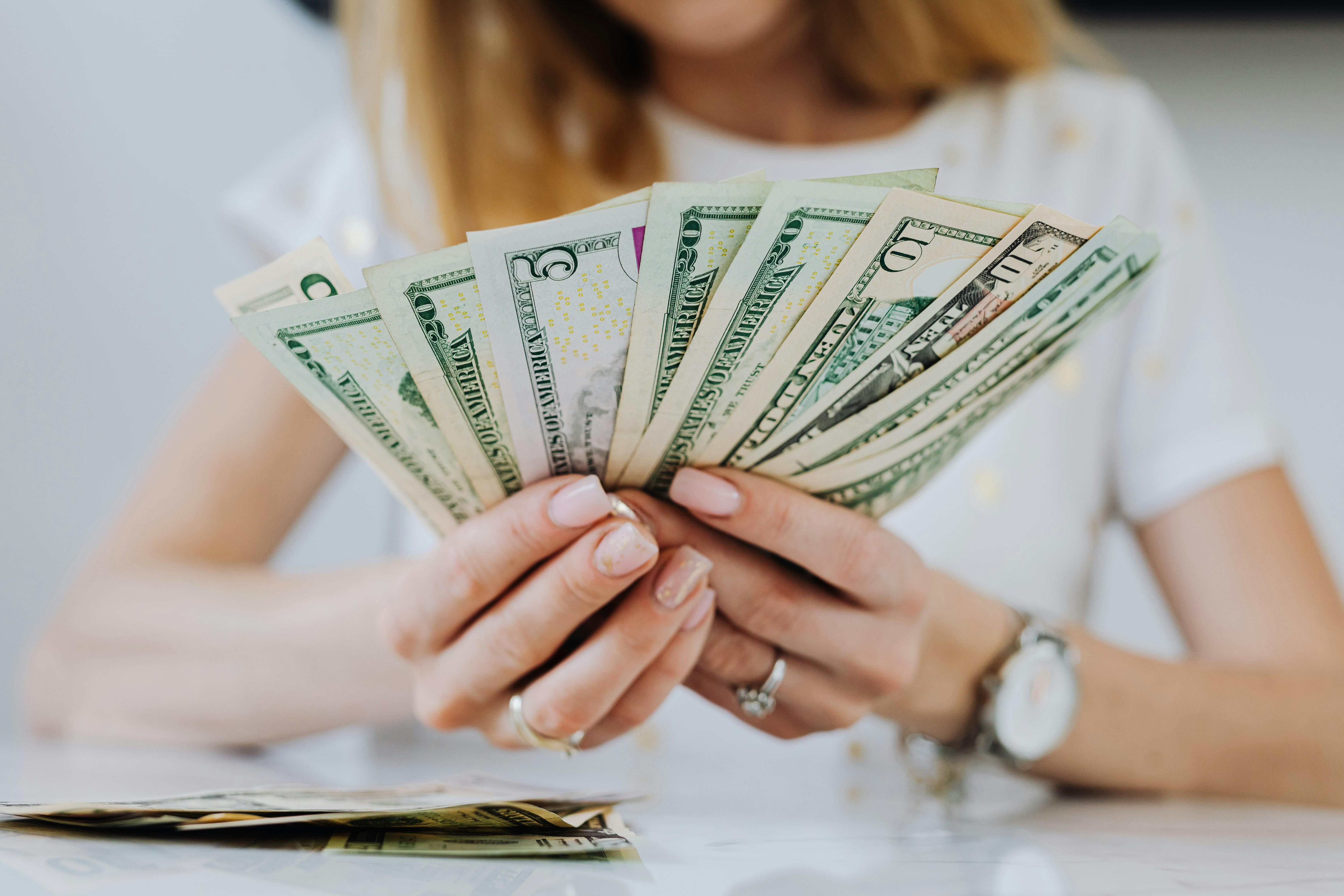 Eine Frau mit Dollarscheinen in der Hand | Quelle: Pexels