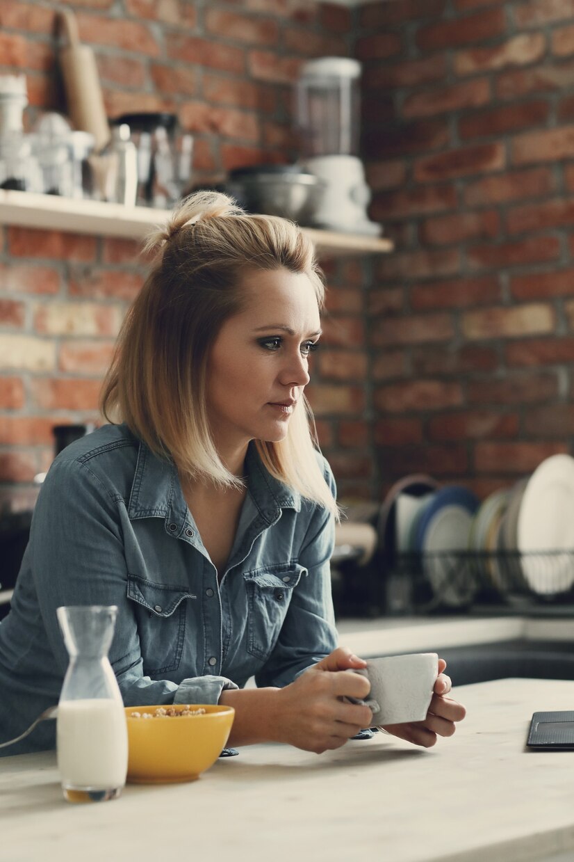 Eine nachdenkliche Frau beim Kaffeetrinken | Quelle: Freepik