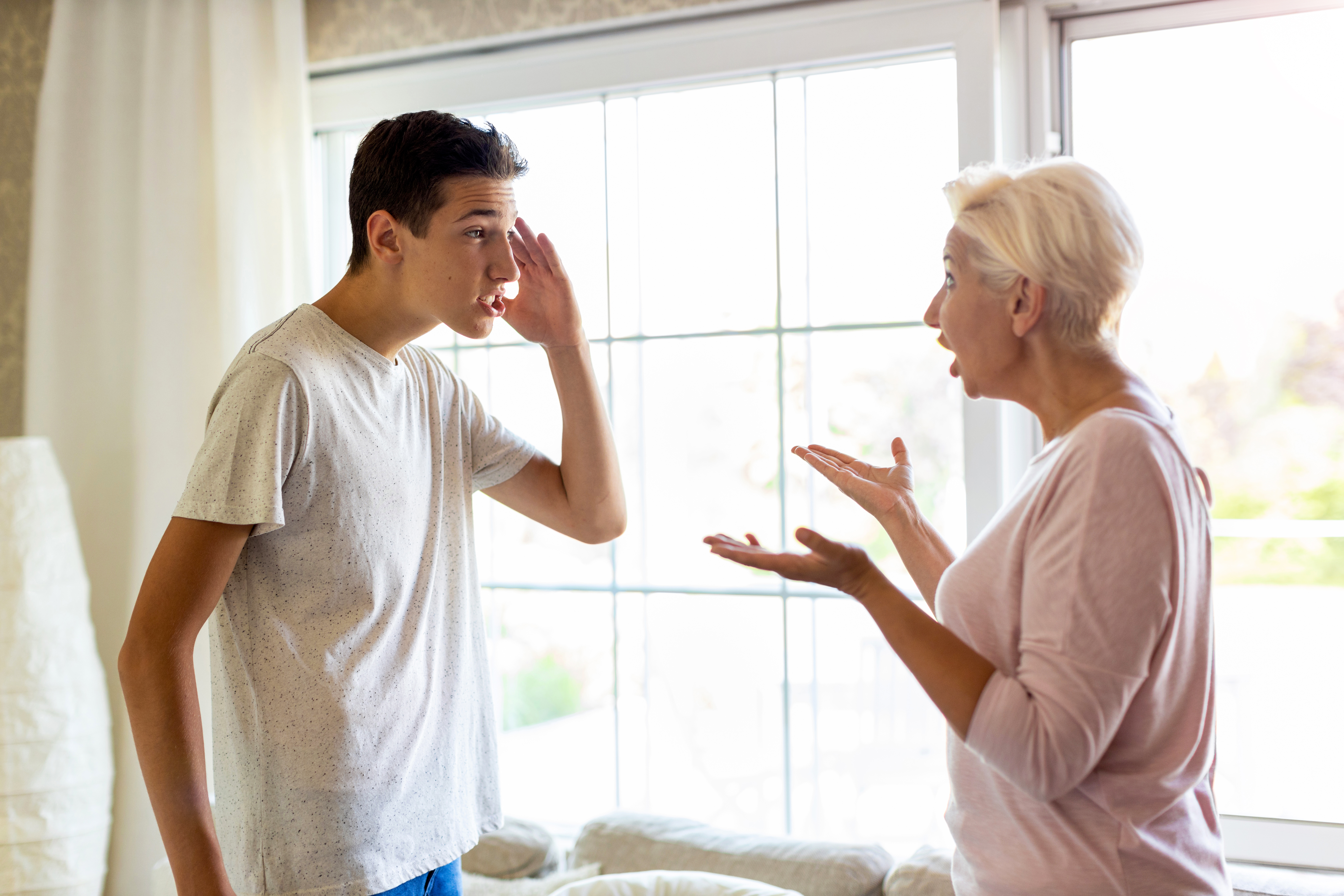 Eine Frau und ihr Sohn im Teenageralter schreien sich gegenseitig an | Quelle: Getty Images