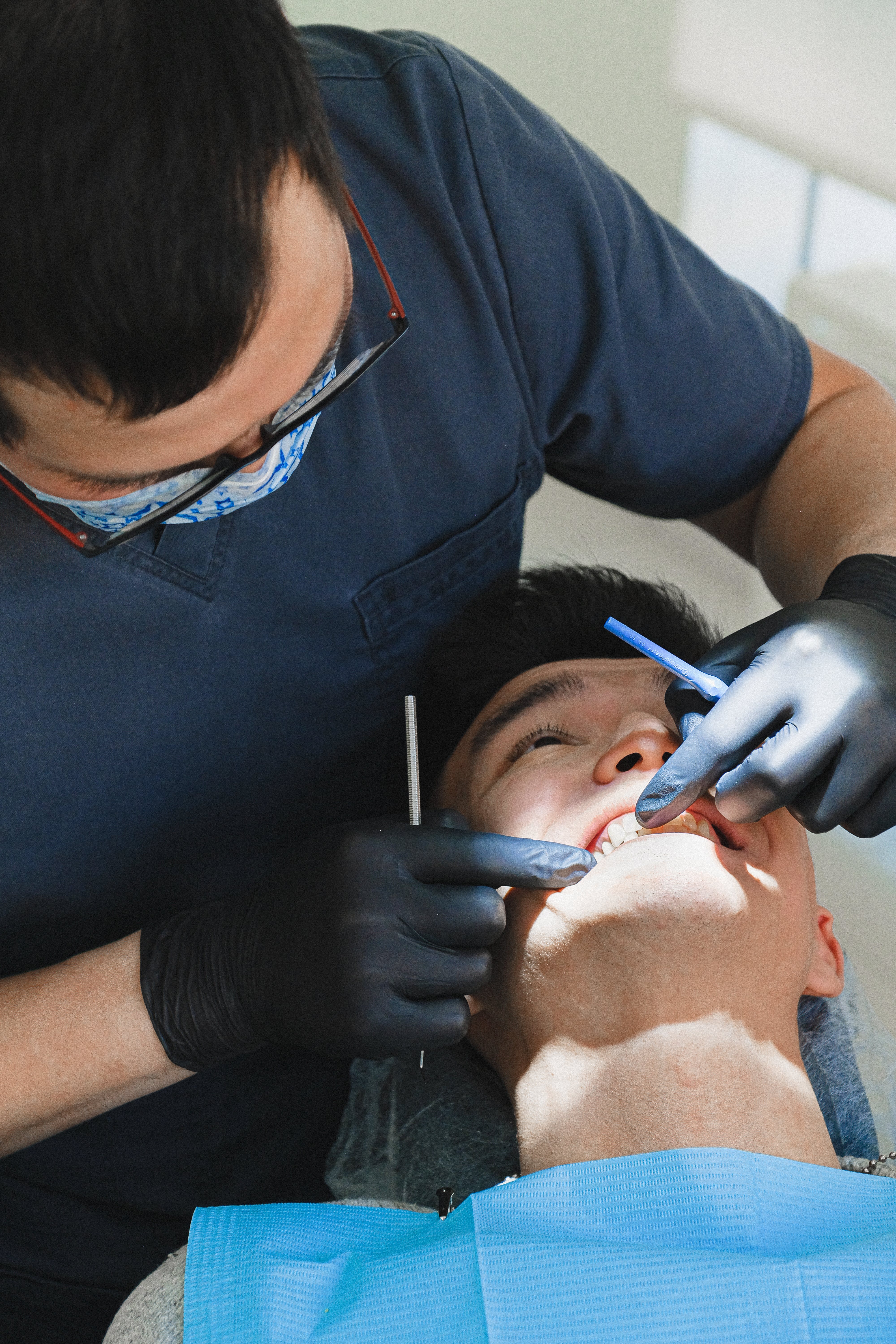 Ein männlicher Zahnarzt, der einen Patienten untersucht. | Quelle: Pexels