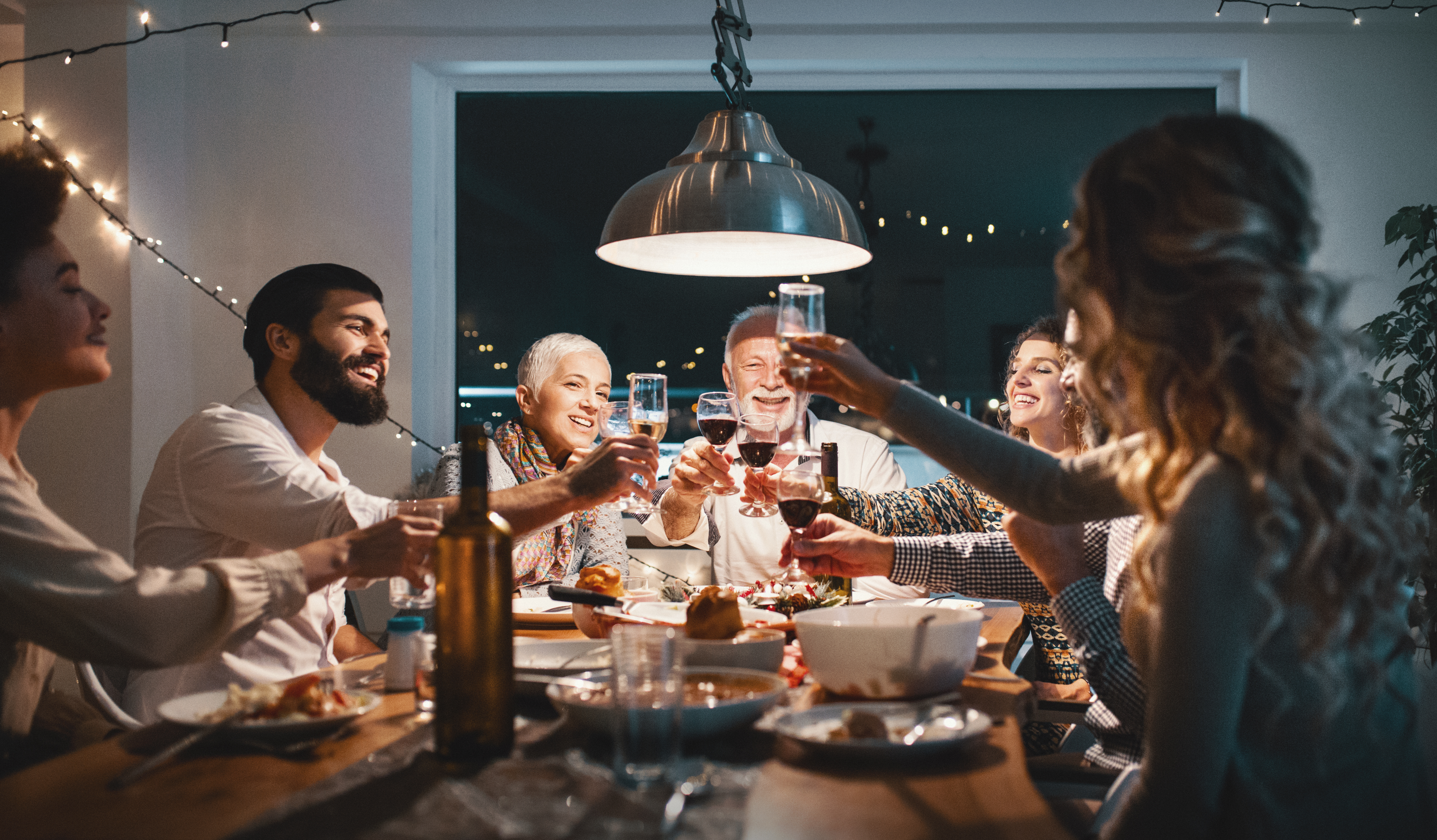 Eine Familie stößt beim Abendessen an | Quelle: Getty Images