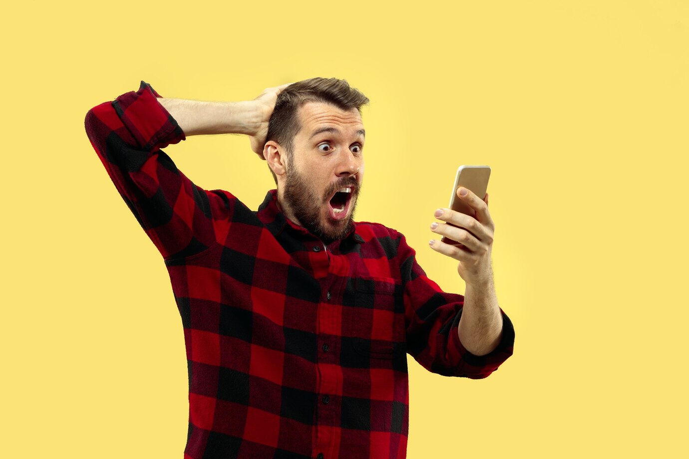 Ein aufgeregter Mann schaut auf sein Telefon | Quelle: Freepik