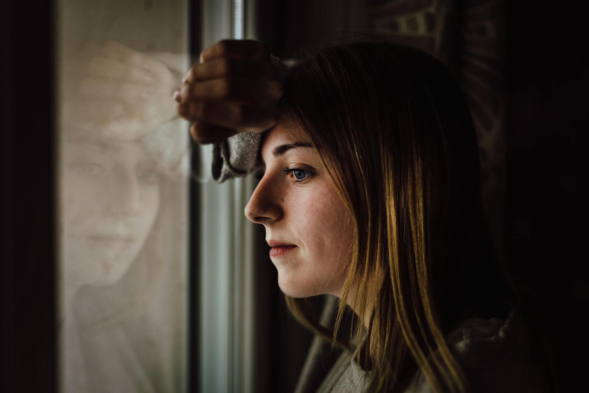 Eine Frau, die aus einem Fenster starrt | Quelle: Pexels