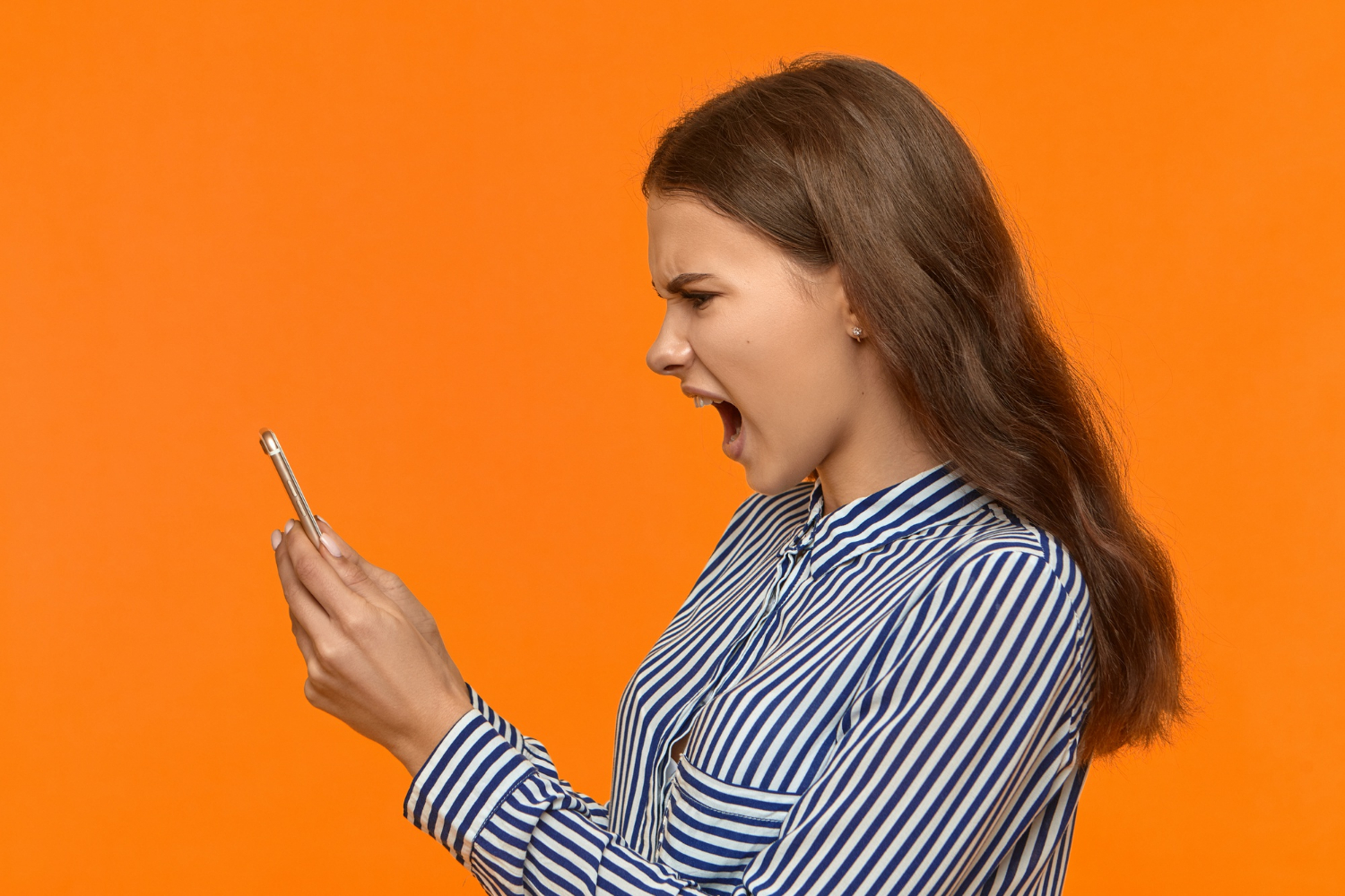 Eine wütende Frau, die auf ihr Telefon schaut und schreit | Quelle: Freepik