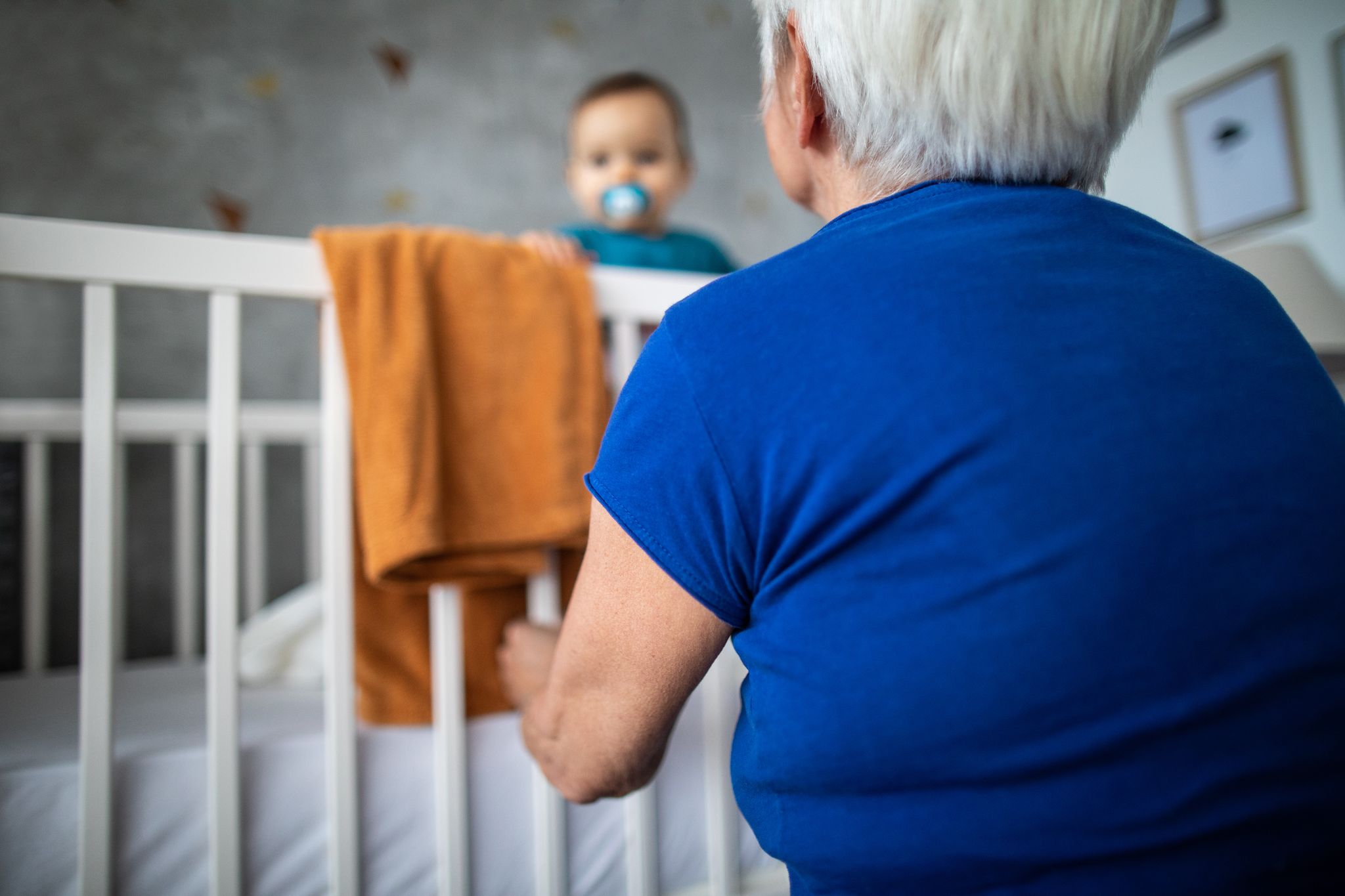 Eine Großmutter und ein Baby in einem Kinderbett | Quelle: Getty Images