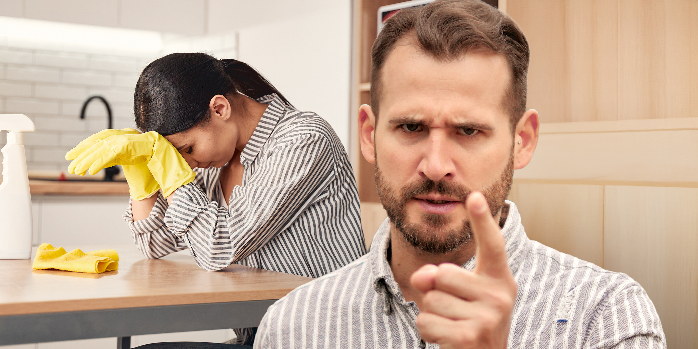 Eine frustrierte Frau versucht zu putzen, während ihr Mann schreit | Quelle: Shutterstock