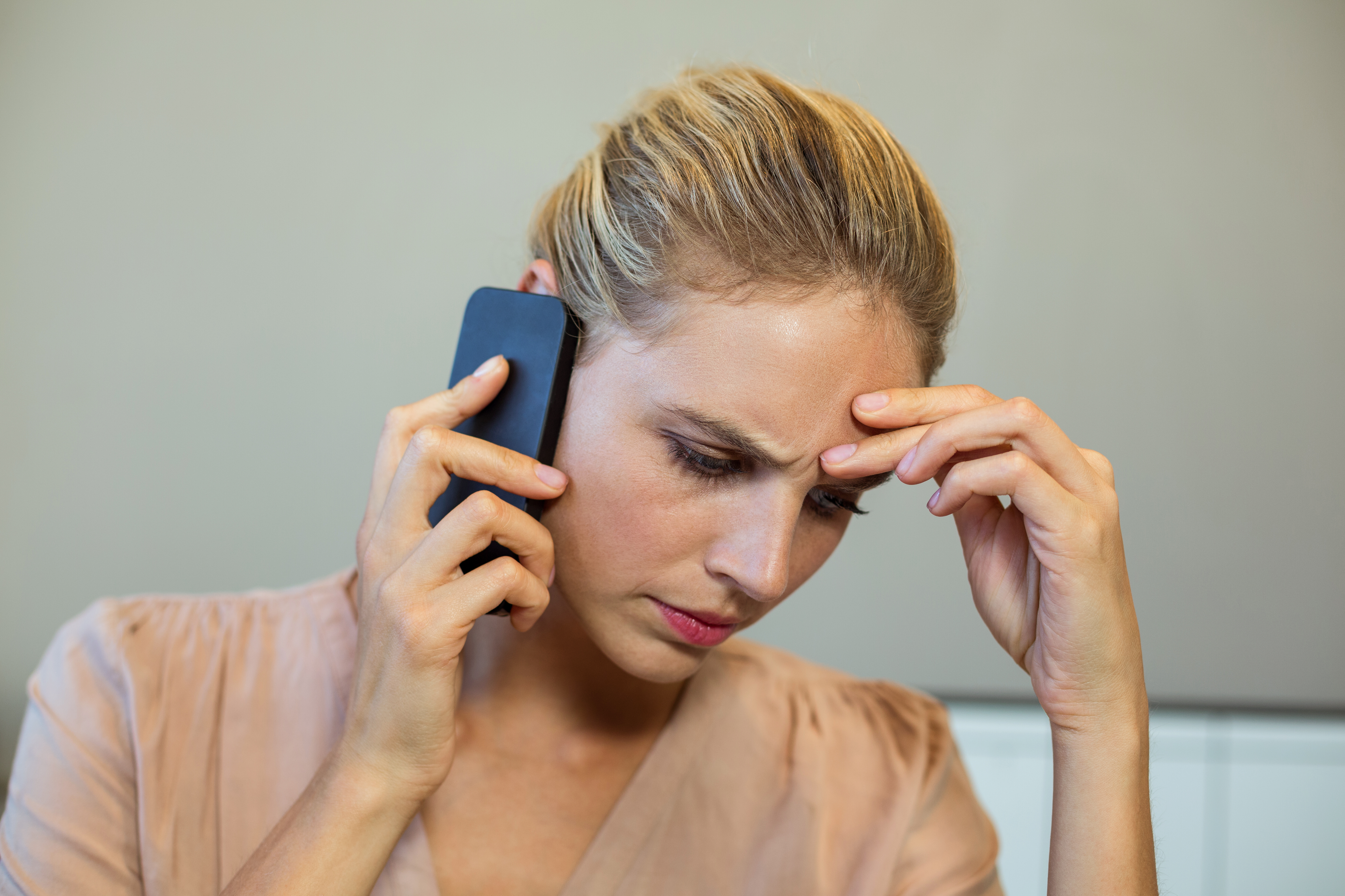 Eine Frau schaut frustriert, während sie telefoniert | Quelle: Shutterstock