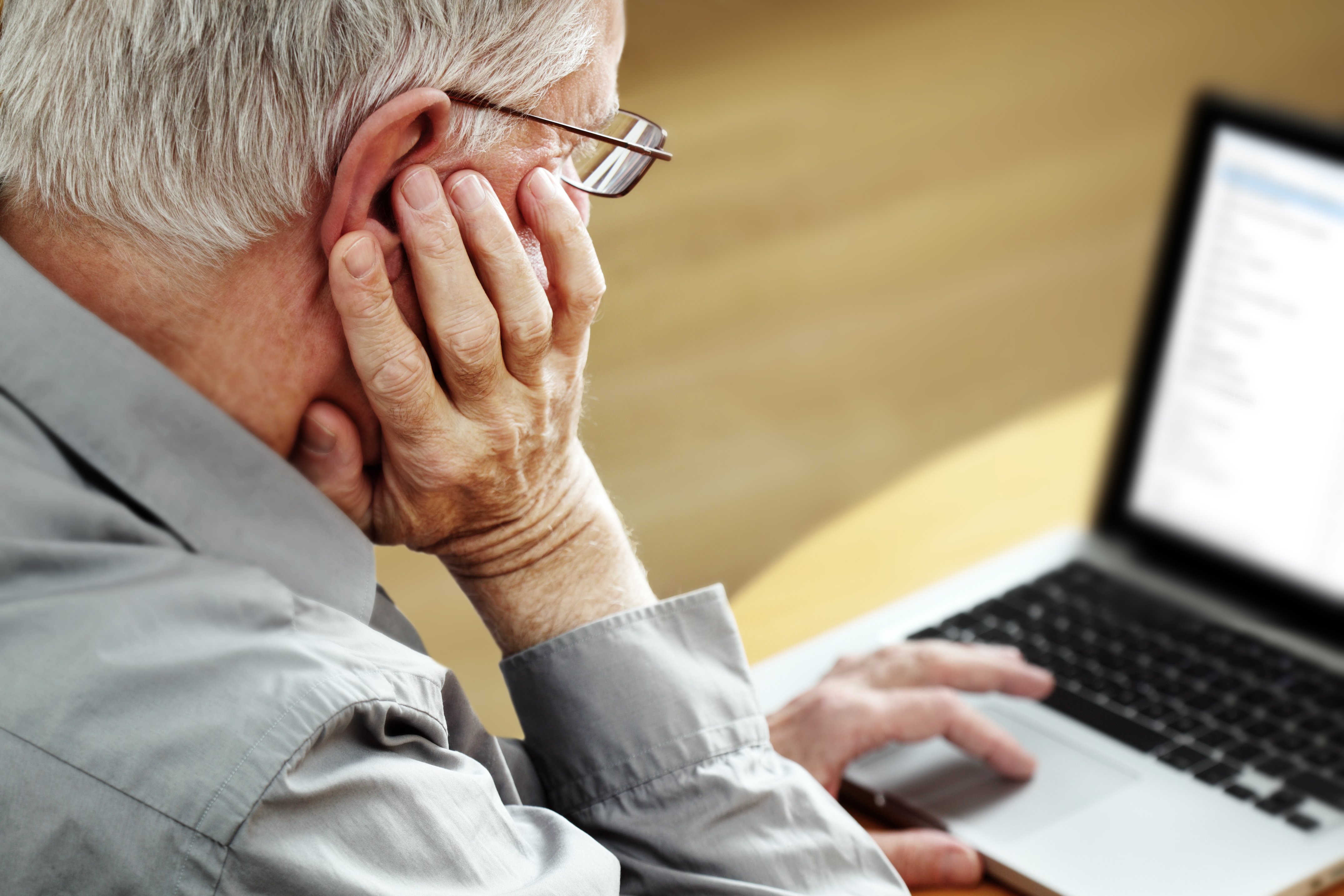 Senior mit Laptop, Fokus auf der Hand | Quelle: Shutterstock