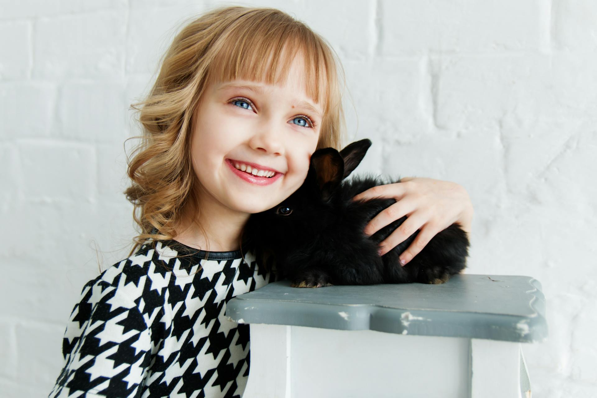 Ein lächelndes Kind, das ein Kaninchen hält | Quelle: Pexels