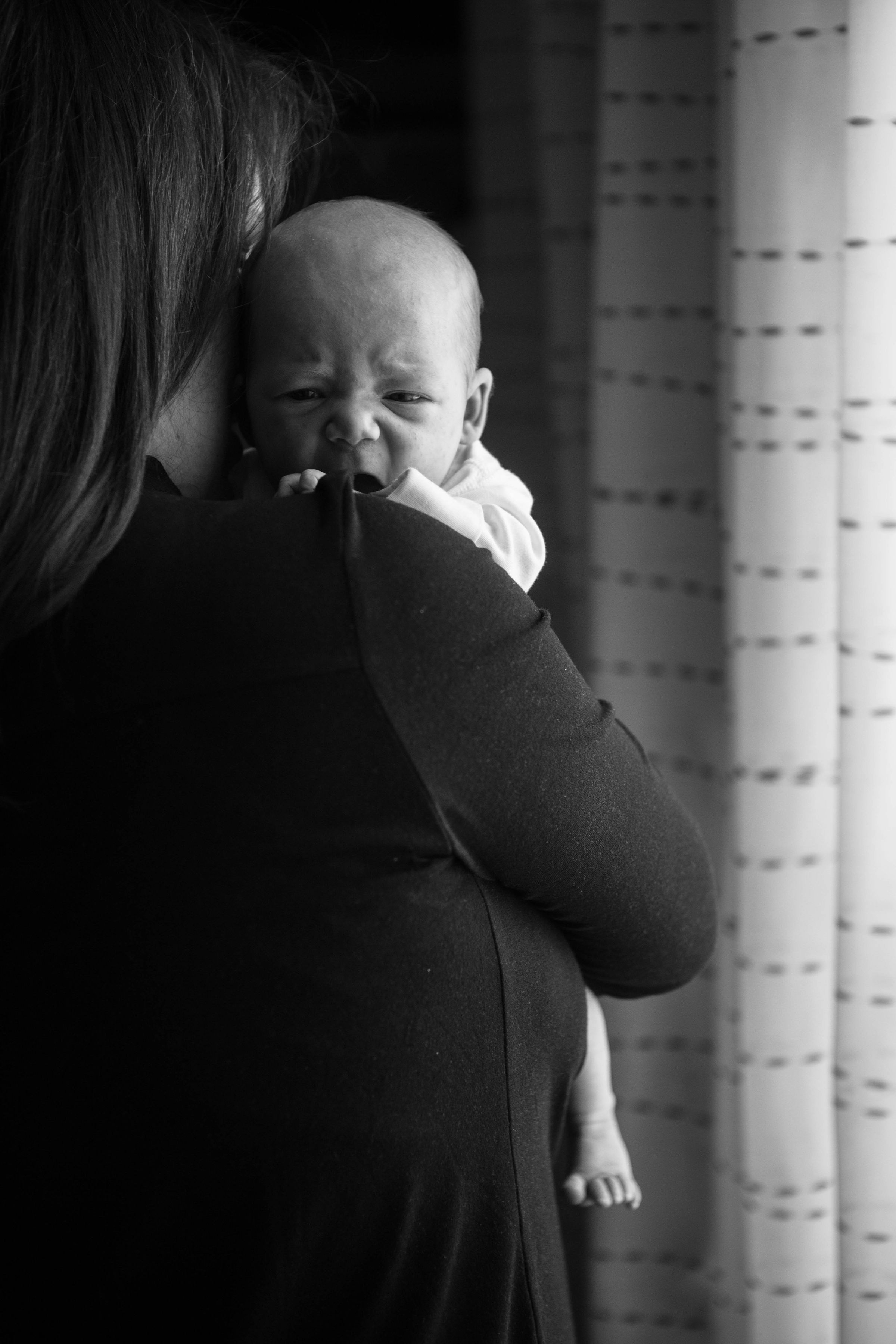 Eine Nahaufnahme einer Frau, die ein weinendes Baby hält | Quelle: Unsplash