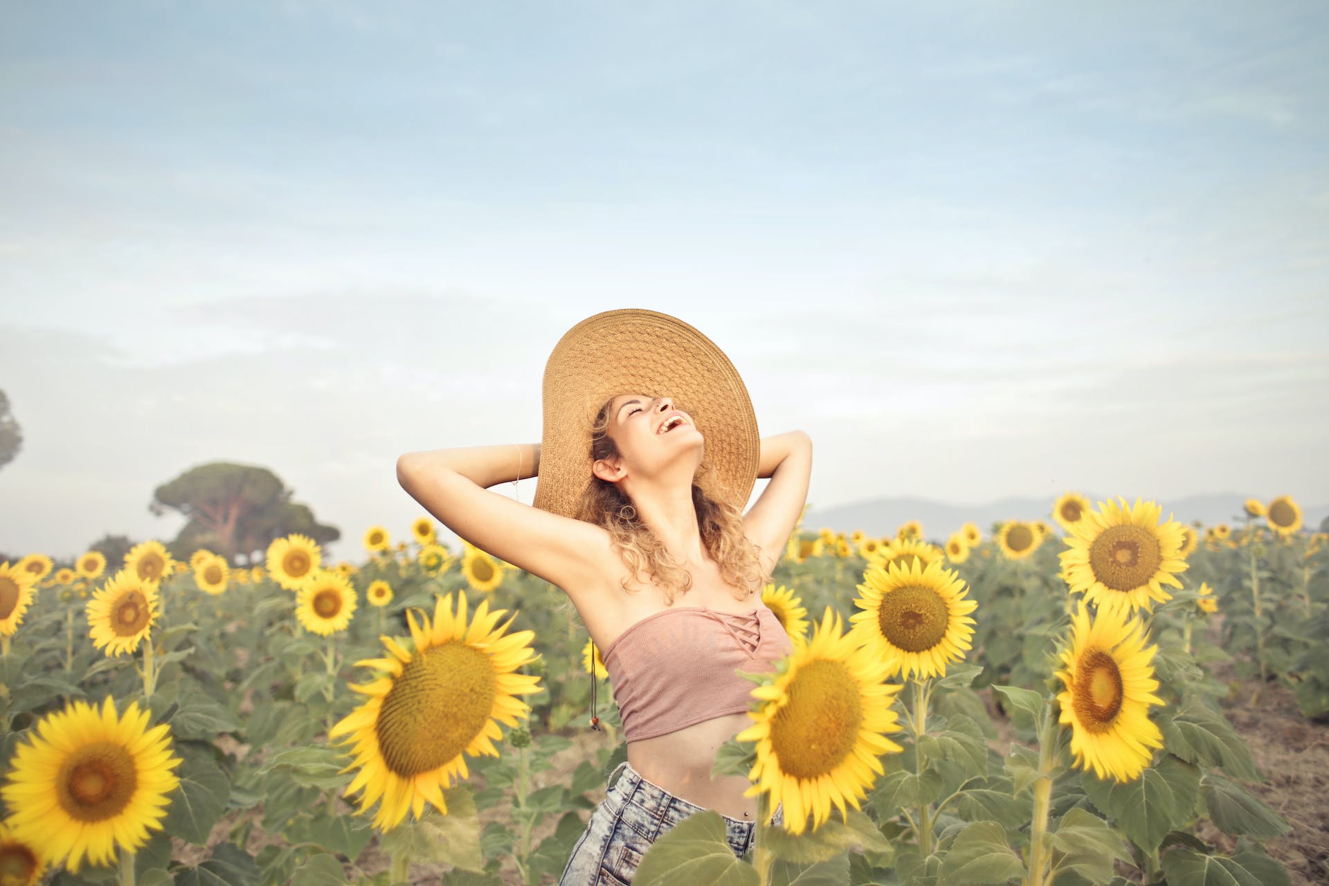 Glückliche Frau in einem Sonnenblumenfeld | Quelle: Pexels