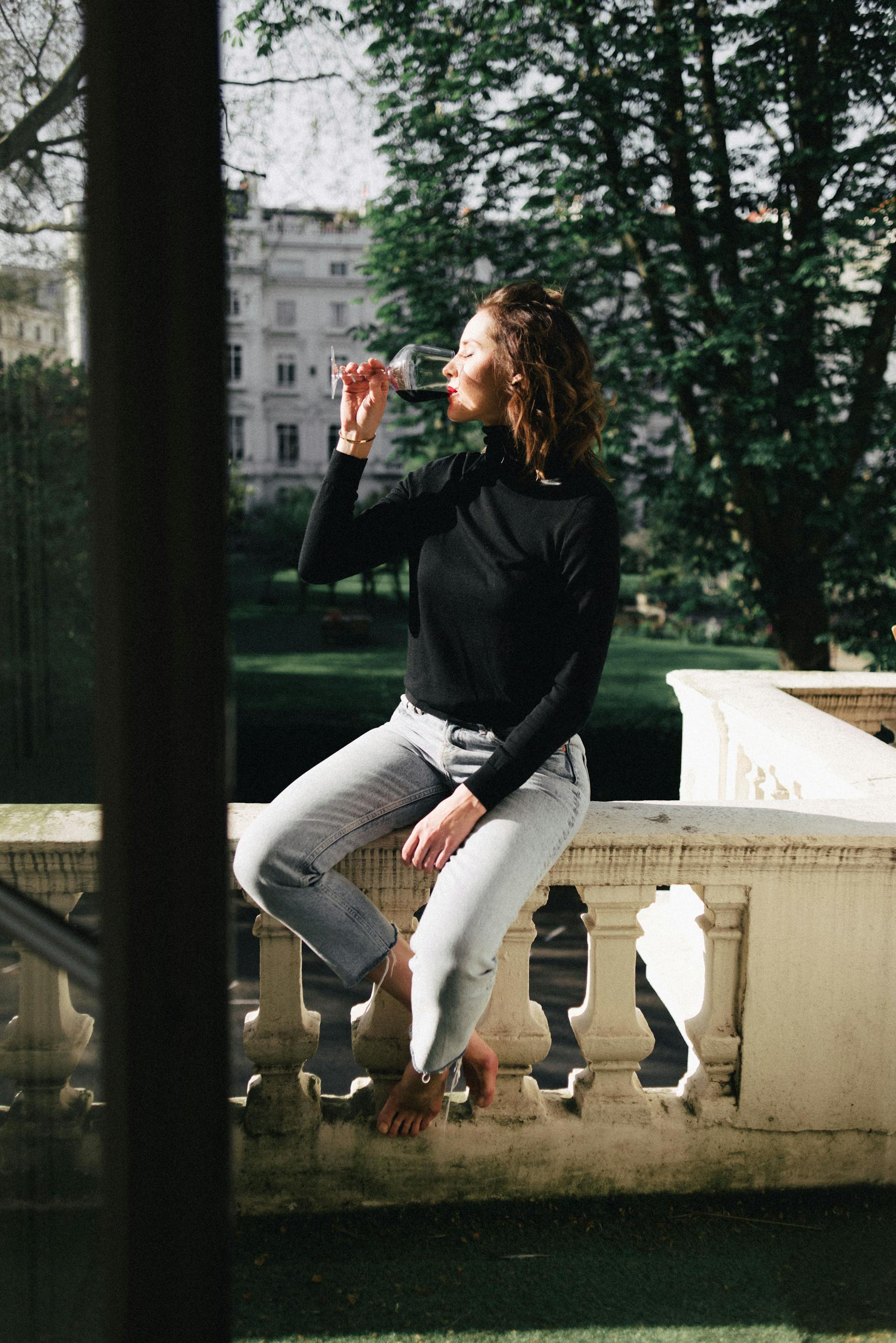 Eine glückliche Frau nippt am Wein | Quelle: Pexels