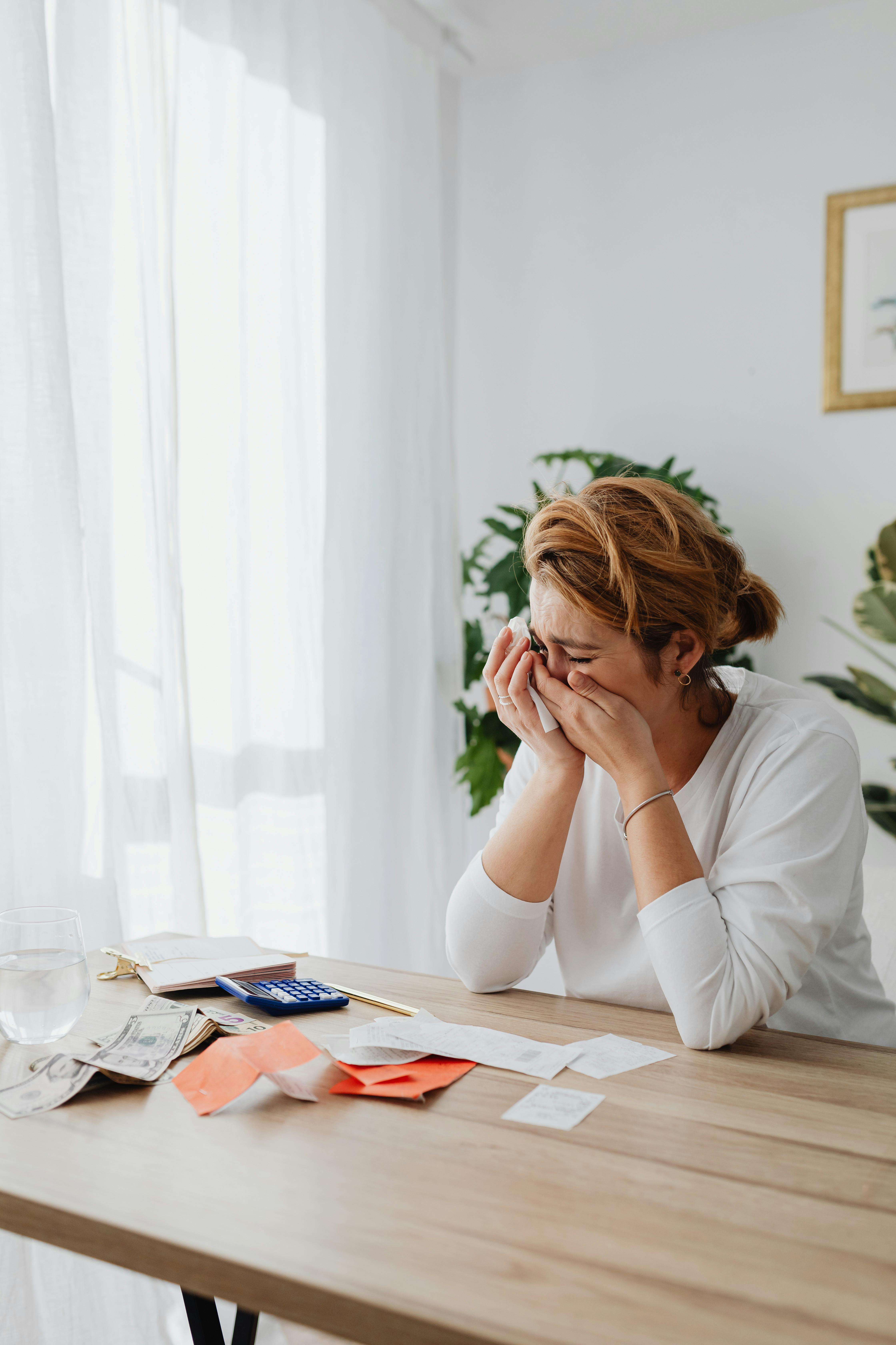 Eine weinende Frau bei der Erledigung von Papierkram | Quelle: Pexels