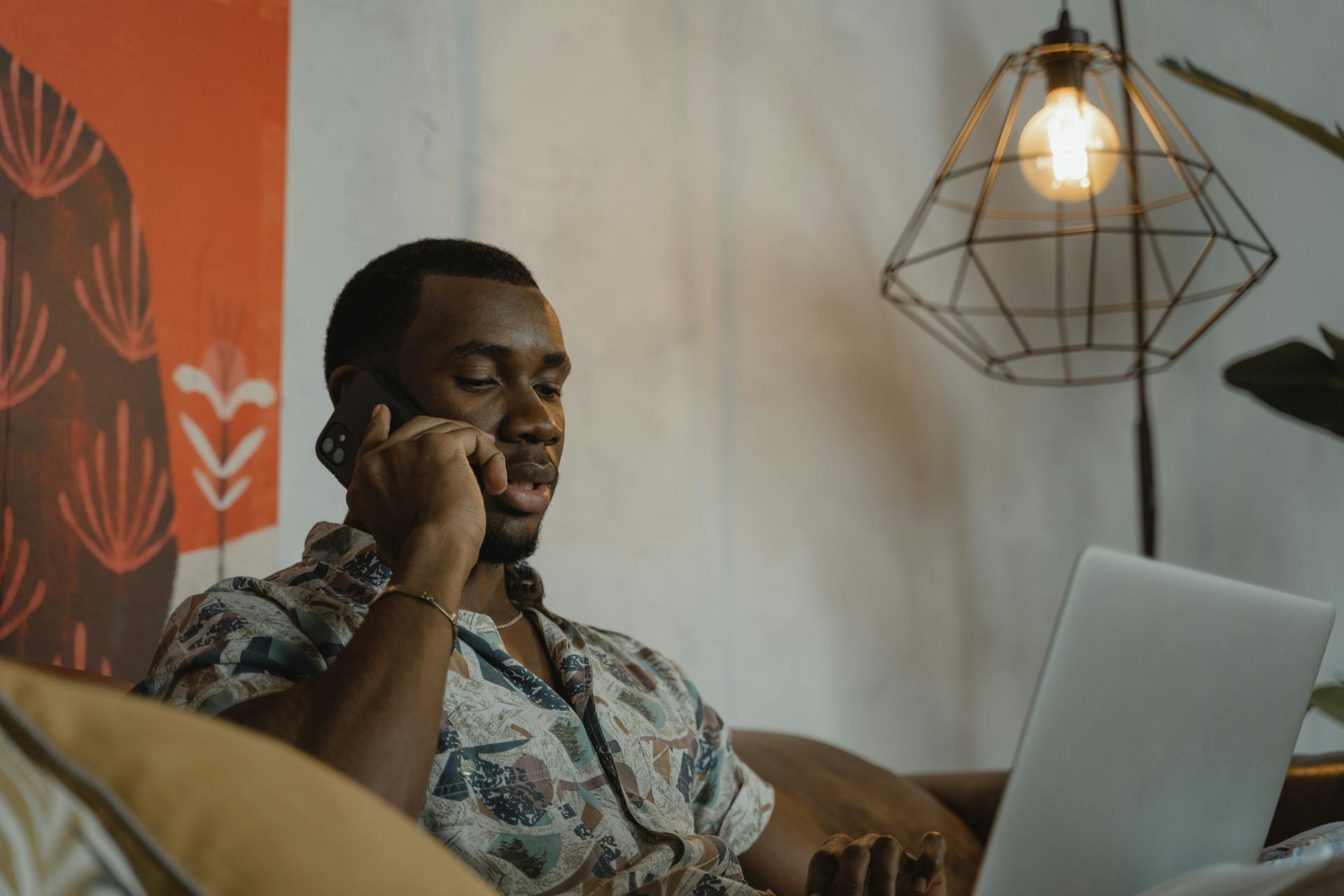Ein Mann starrt auf seinen Laptop, während er telefoniert | Quelle: Pexels