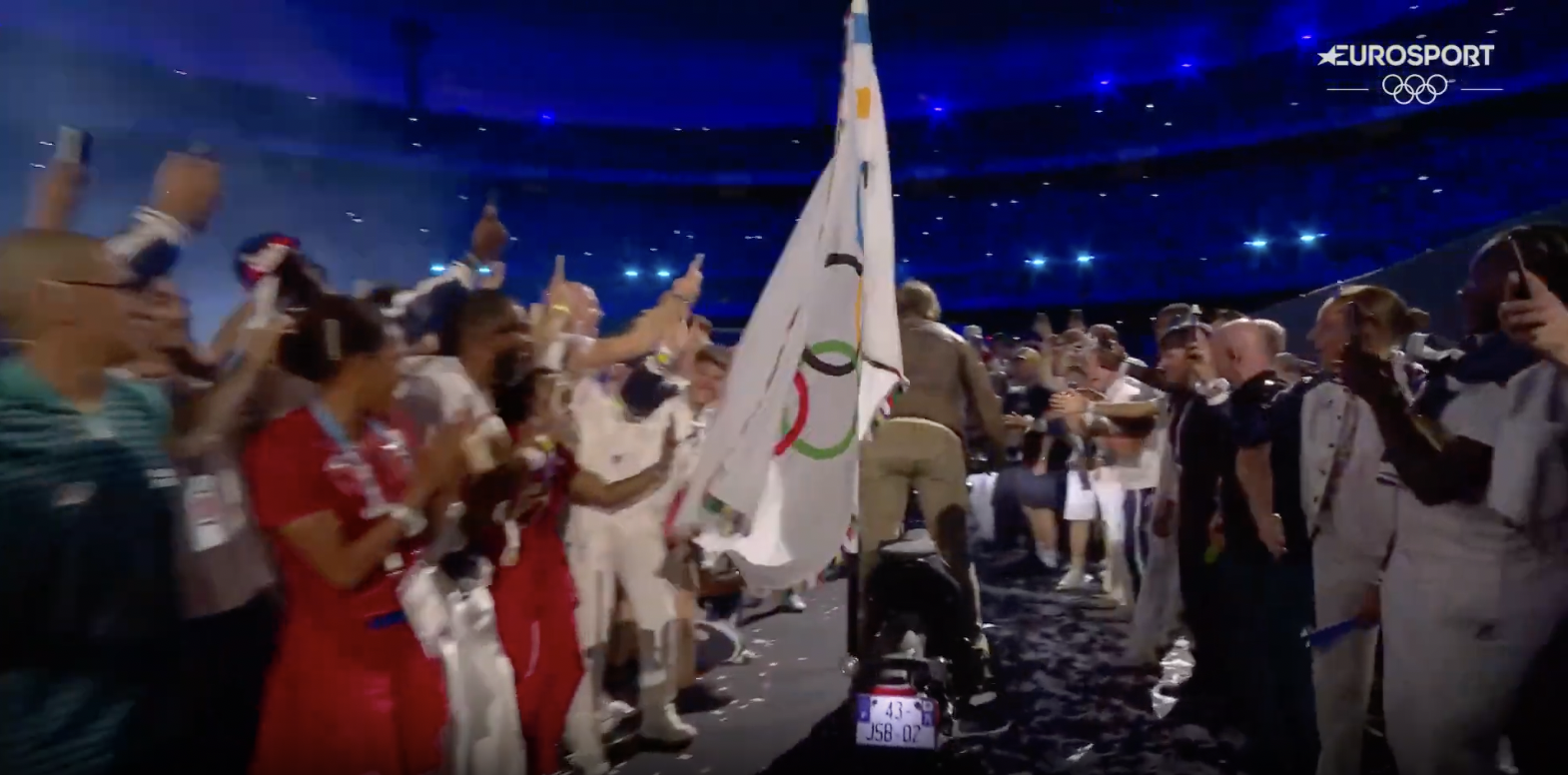 Tom Cruise beim Verlassen des Stadions mit der olympischen Flagge, aufgenommen am 12. August 2024 | Quelle: YouTube/Eurosport