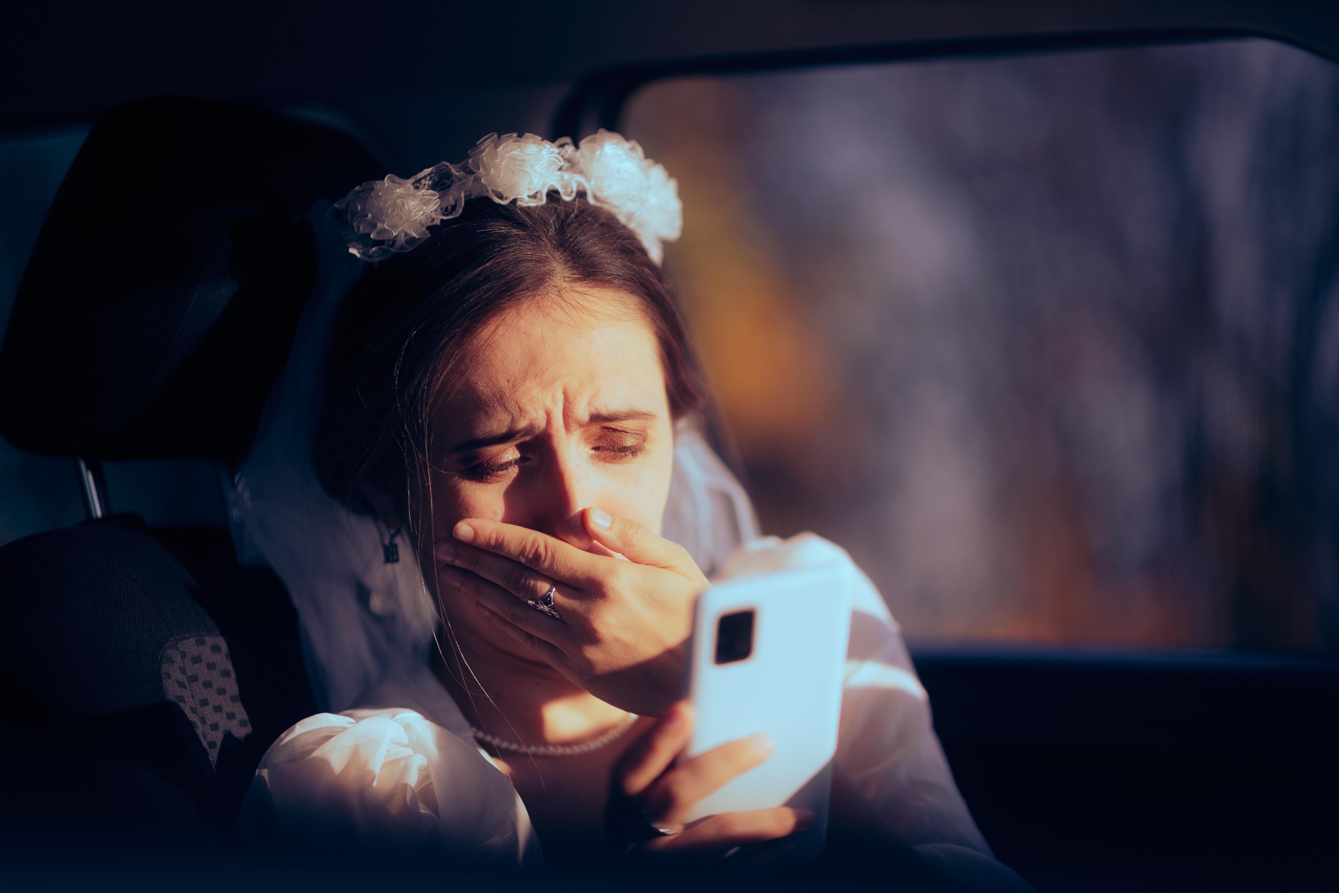 Eine weinende Braut, die auf ihr Smartphone schaut | Quelle: Shutterstock