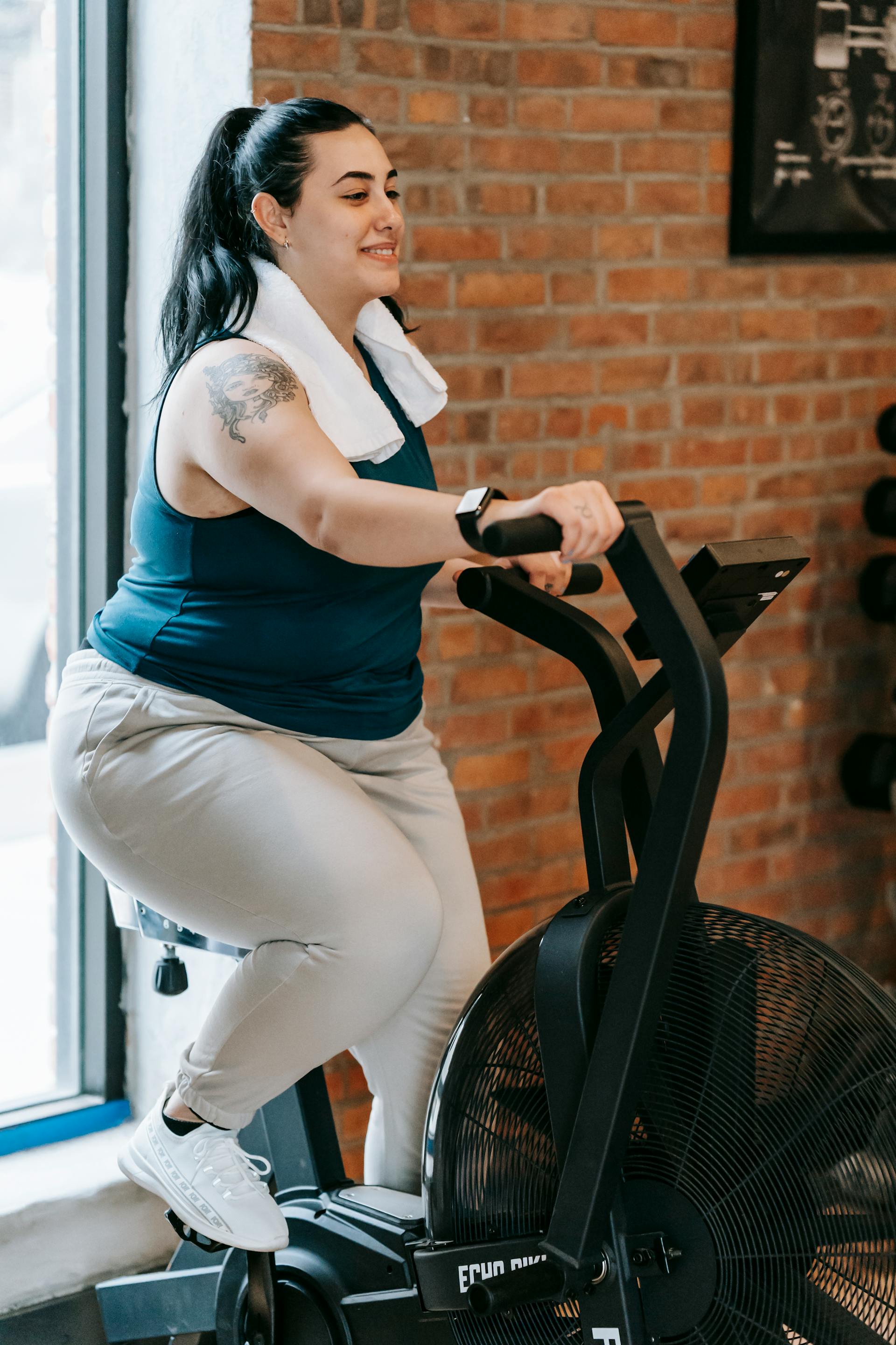 Eine Plus-Size-Frau auf einem Crosstrainer in einem Fitnessstudio | Quelle: Pexels