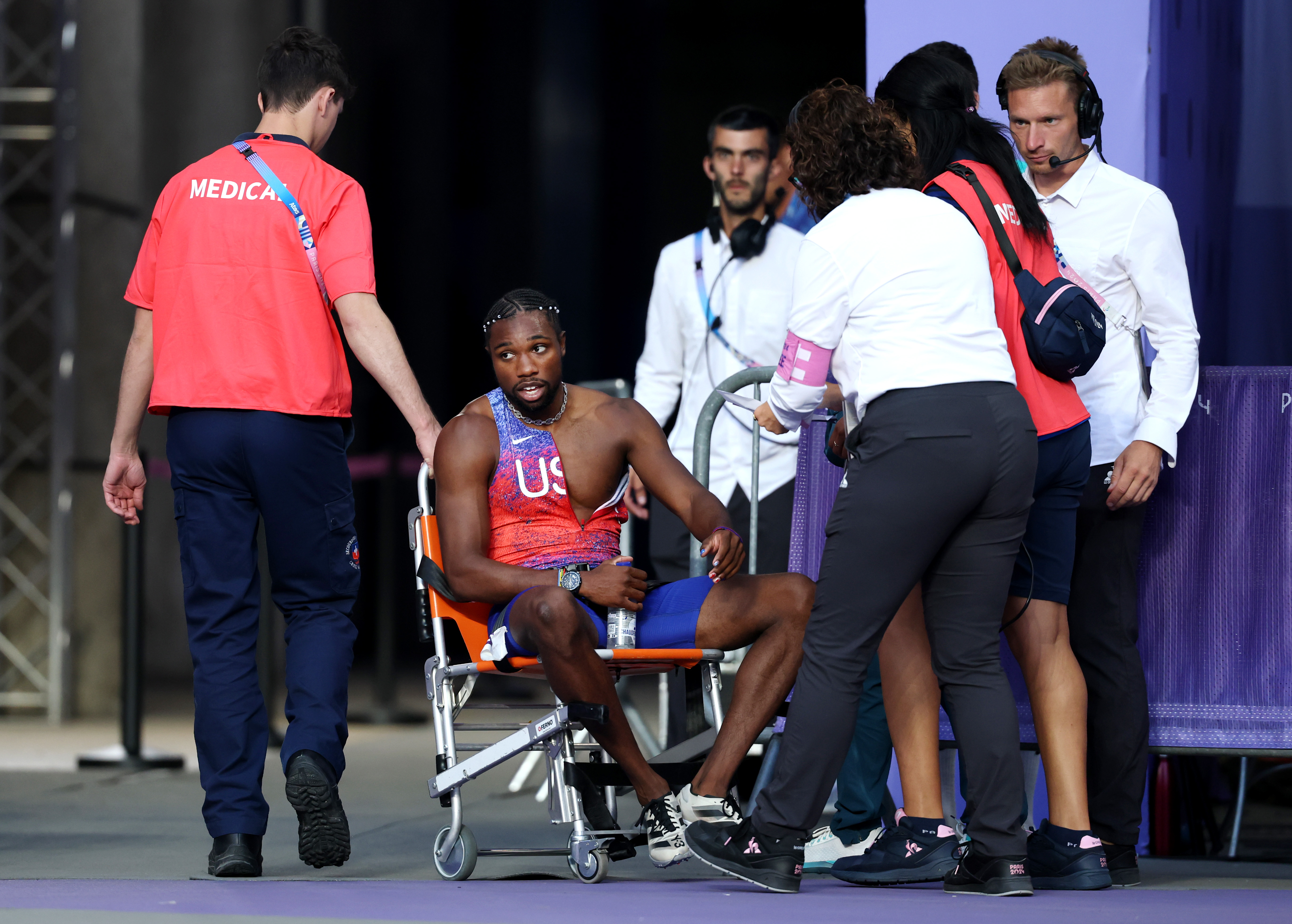 Noah Lyles vom U.S.-Team wird nach dem 200-Meter-Finale der Männer bei den Olympischen Spielen am 8. August 2024 in Paris, Frankreich, mit einem Rollstuhl von der Bahn gefahren | Quelle: Getty Images